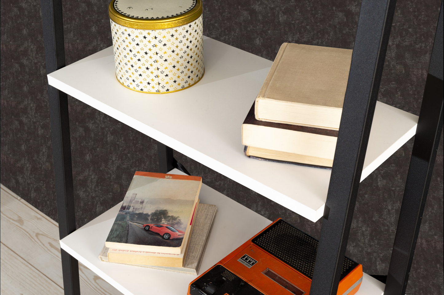 Decorative tin with gold and black stars on a white shelf
