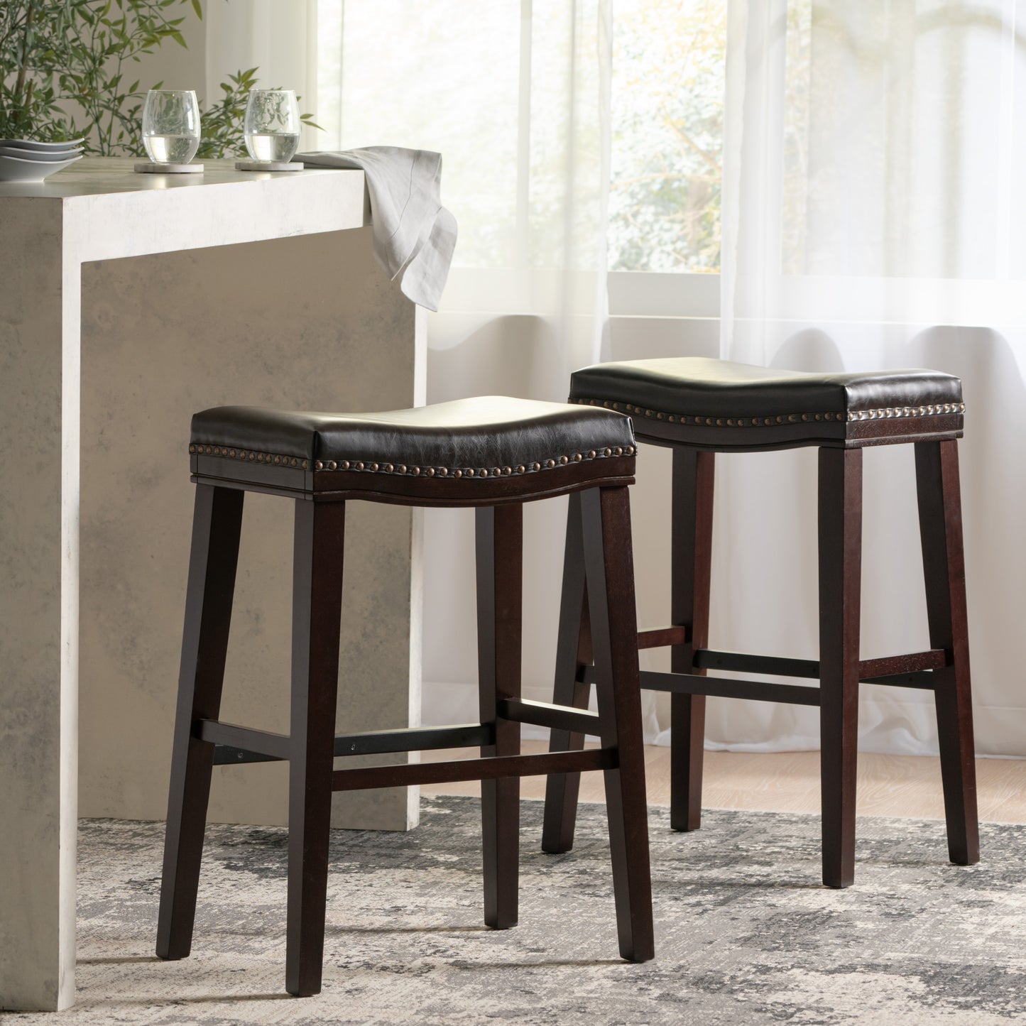 Dark brown leatherette bar stool with nailhead trim and dark wood legs