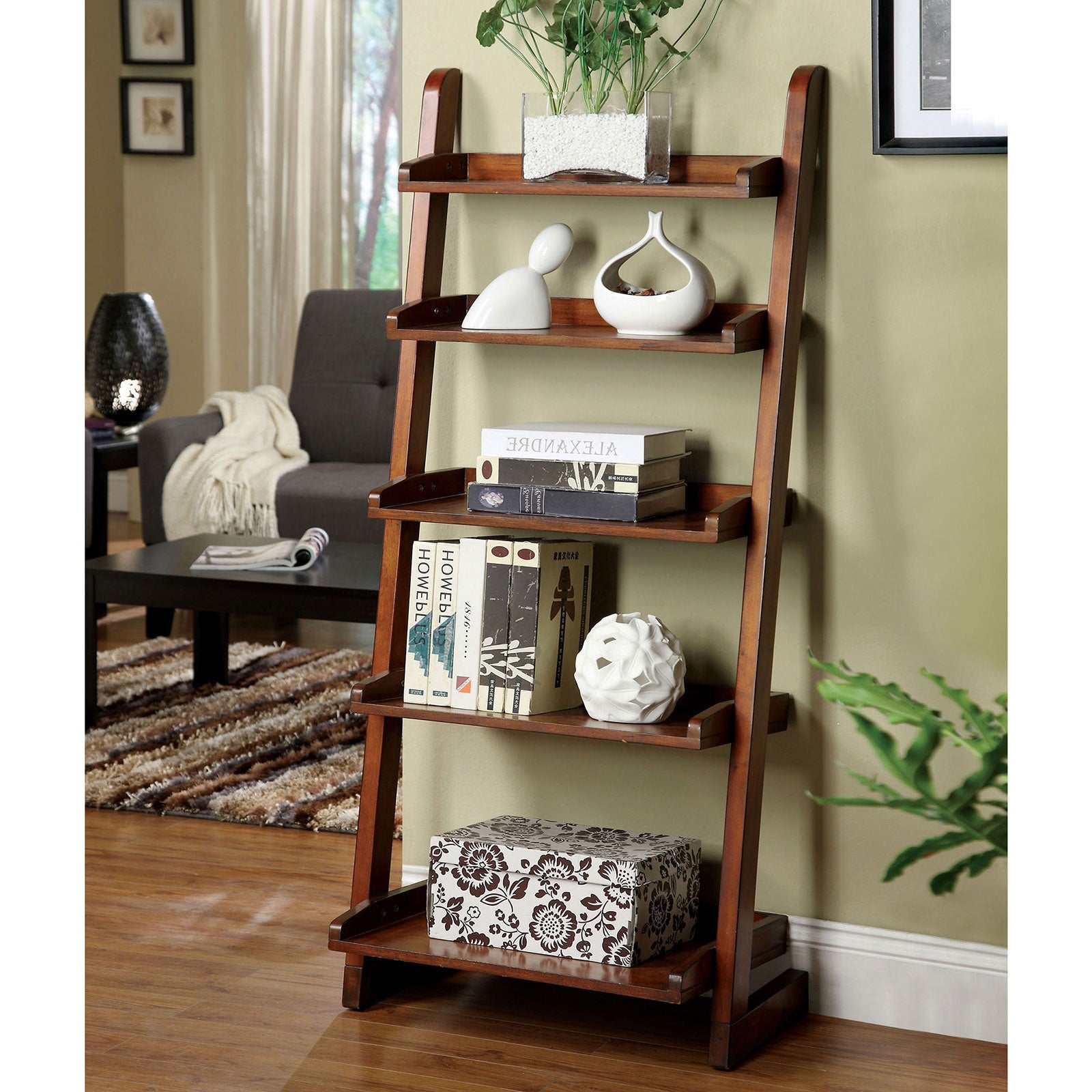 Dark brown wooden ladder shelf displaying books and decor