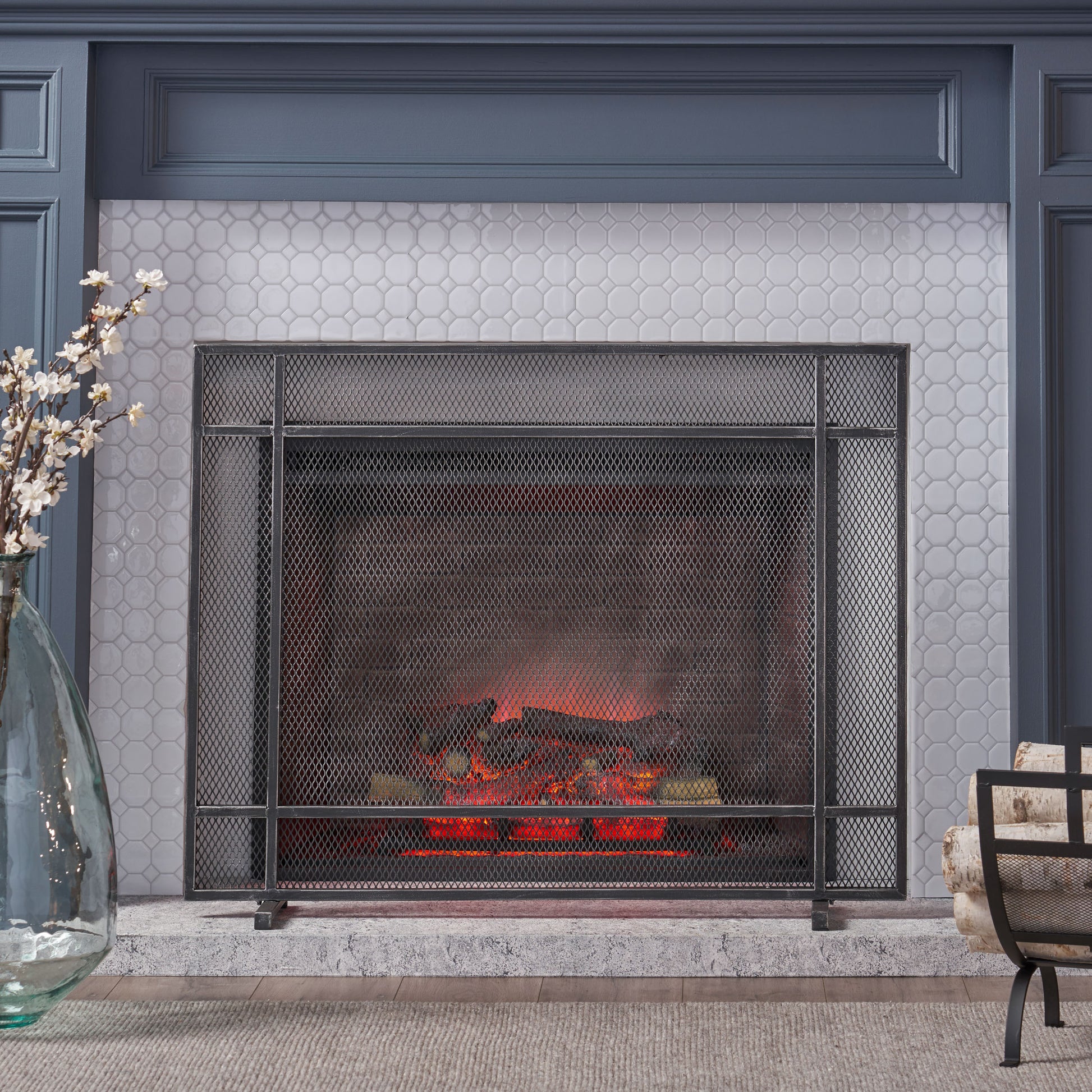 Industrial mesh fireplace screen with realistic faux logs