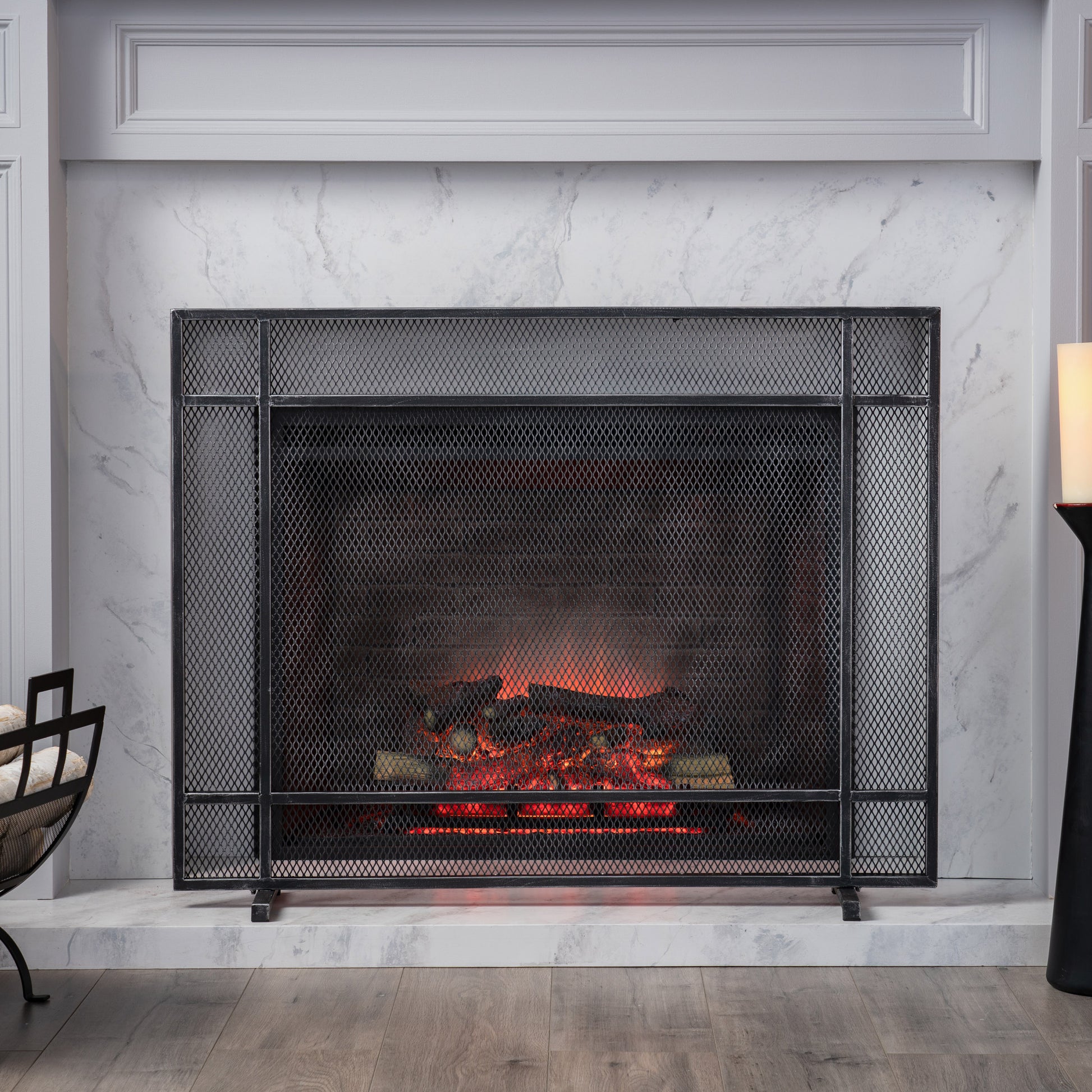 Black metal fireplace screen with diamond mesh over a realistic fire effect