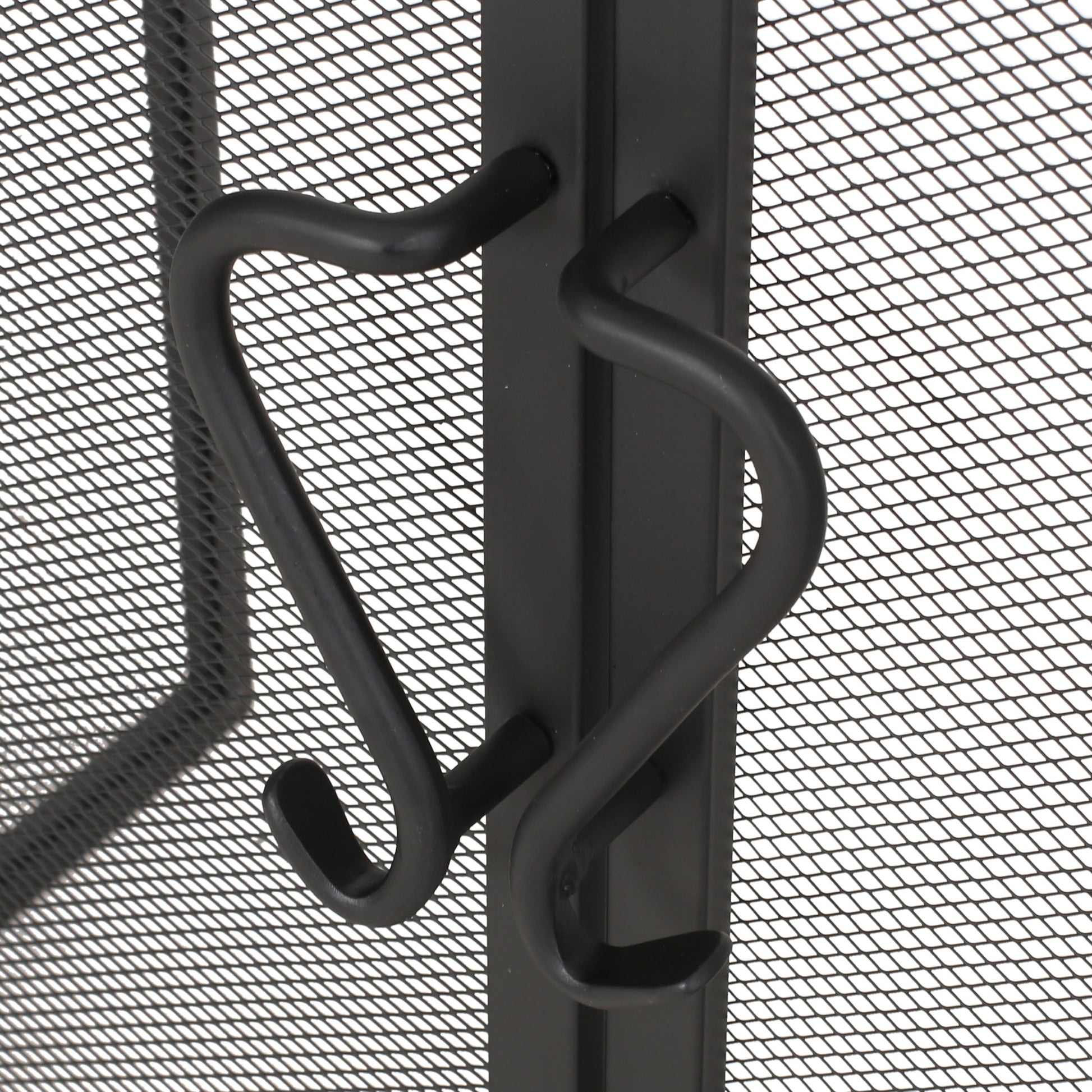 Black metal fireplace screen with decorative curved handles