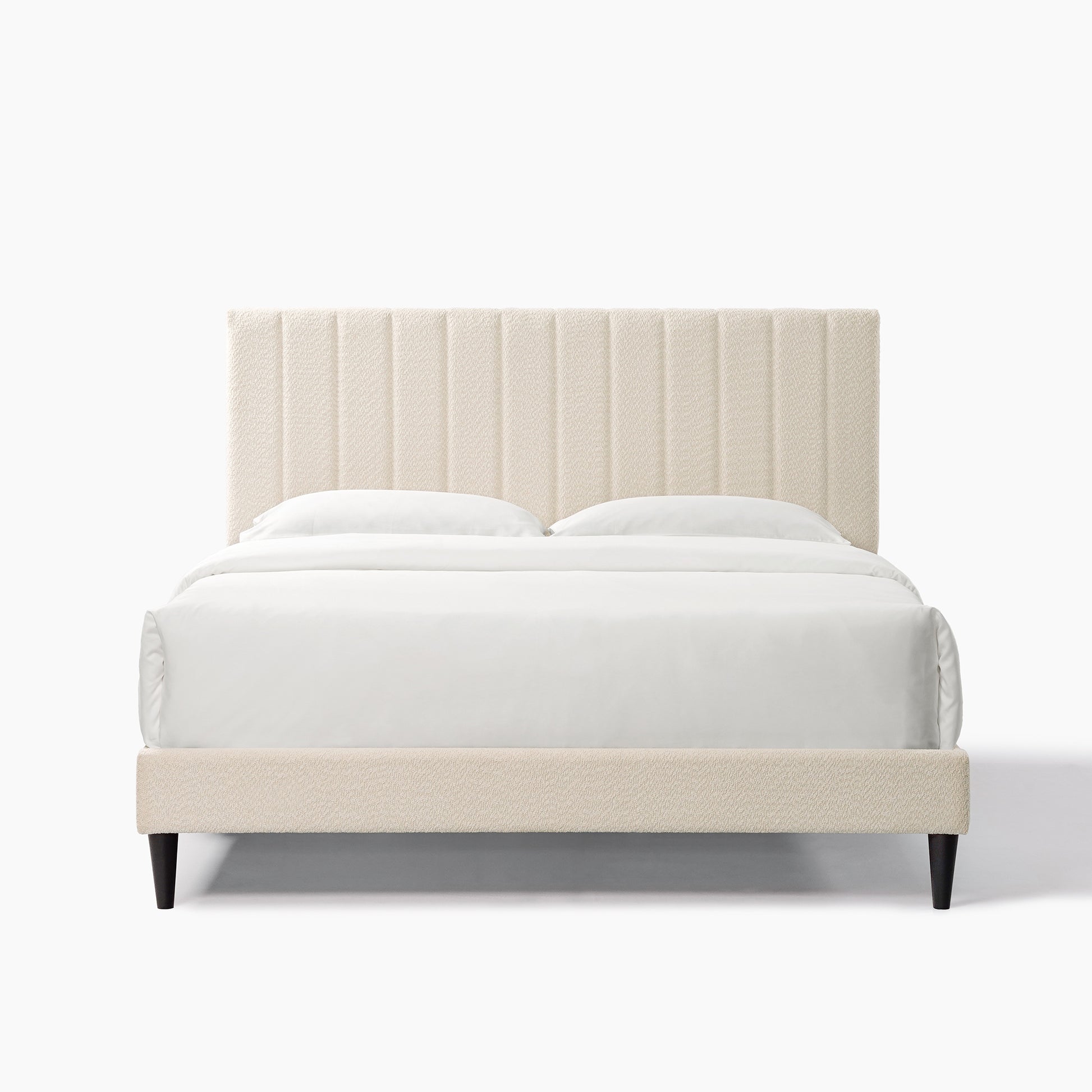 Cream boucle upholstered bed frame with vertical channel tufting on headboard