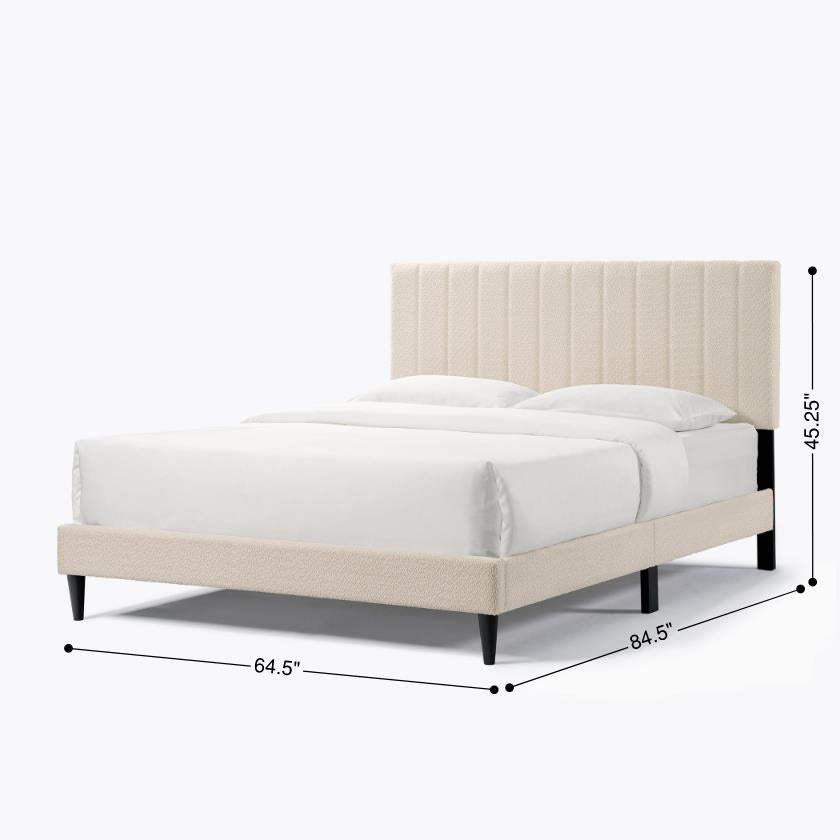 Cream upholstered platform bed with channel tufted headboard and dark wooden legs