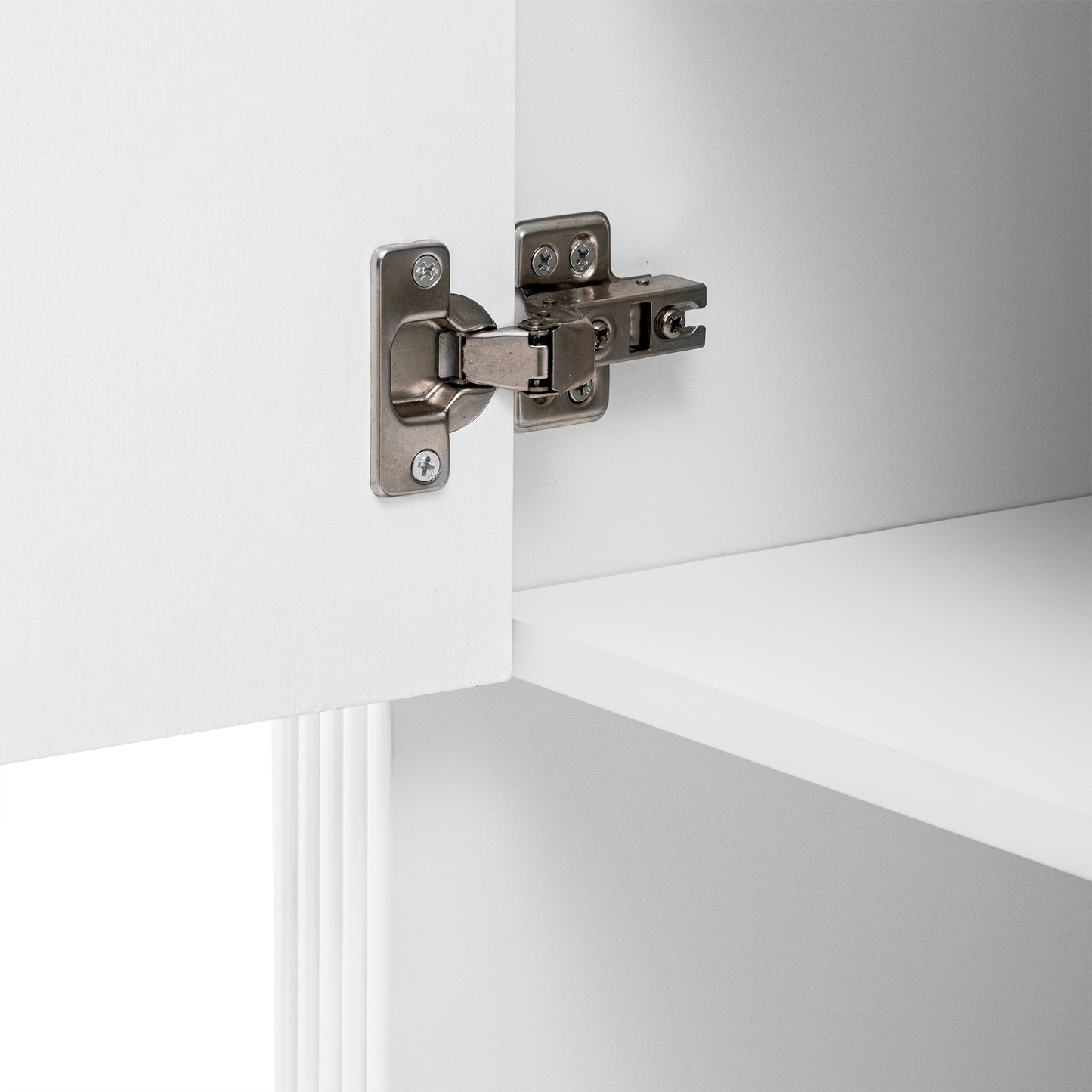 Closeup of brushed nickel cabinet hinge attached to white cabinet door