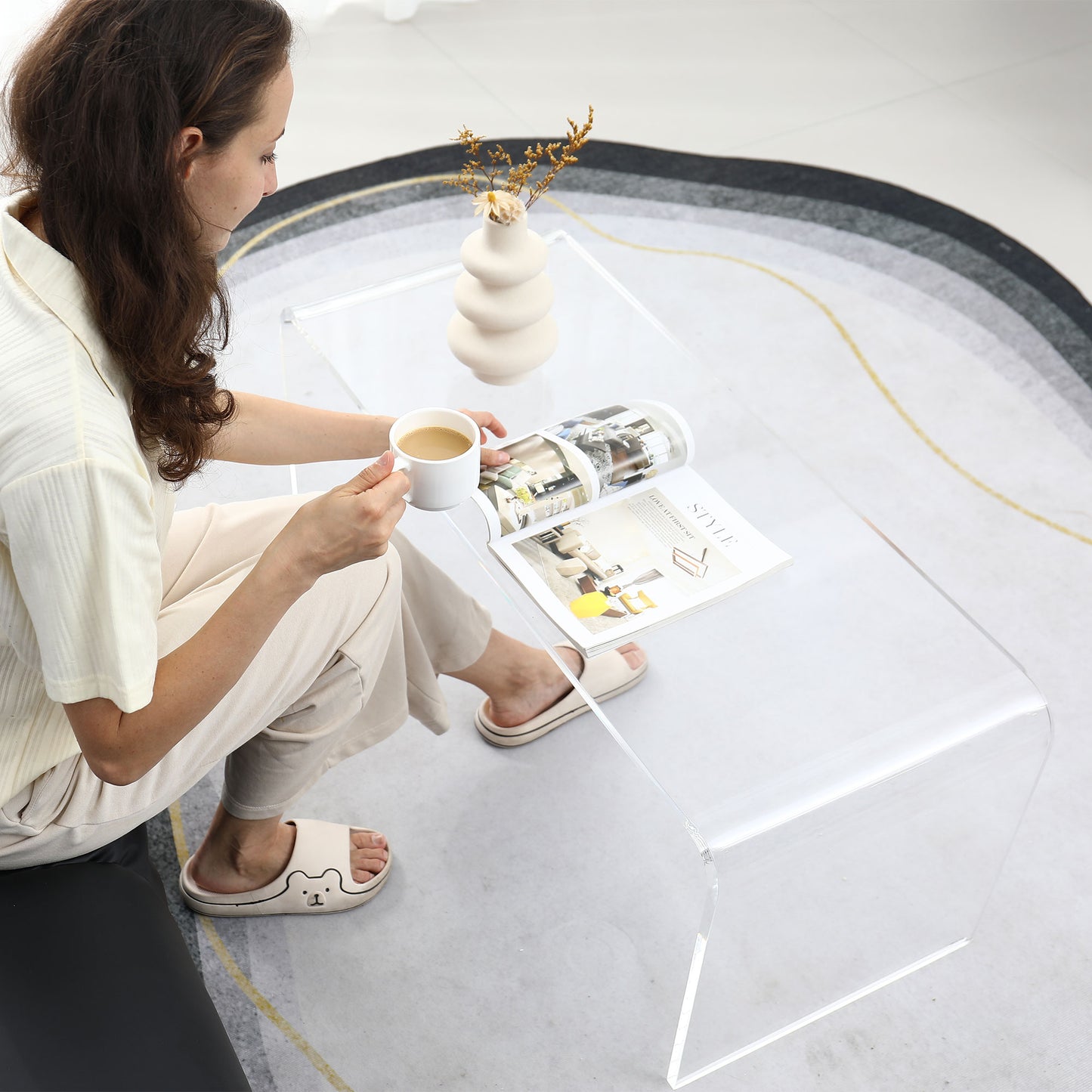 Clear acrylic waterfall coffee table with rounded edges showcasing modern living room decor