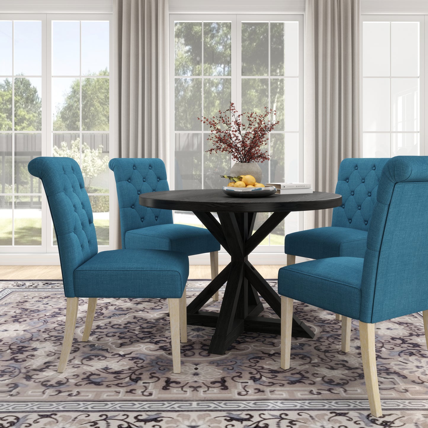 Tufted teal dining chairs around a dark wood pedestal table