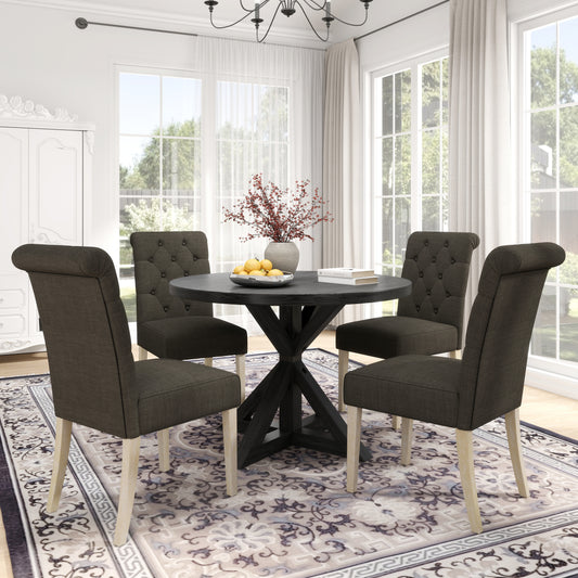 Dark gray tufted dining chairs with light wood legs around a dark wood pedestal table