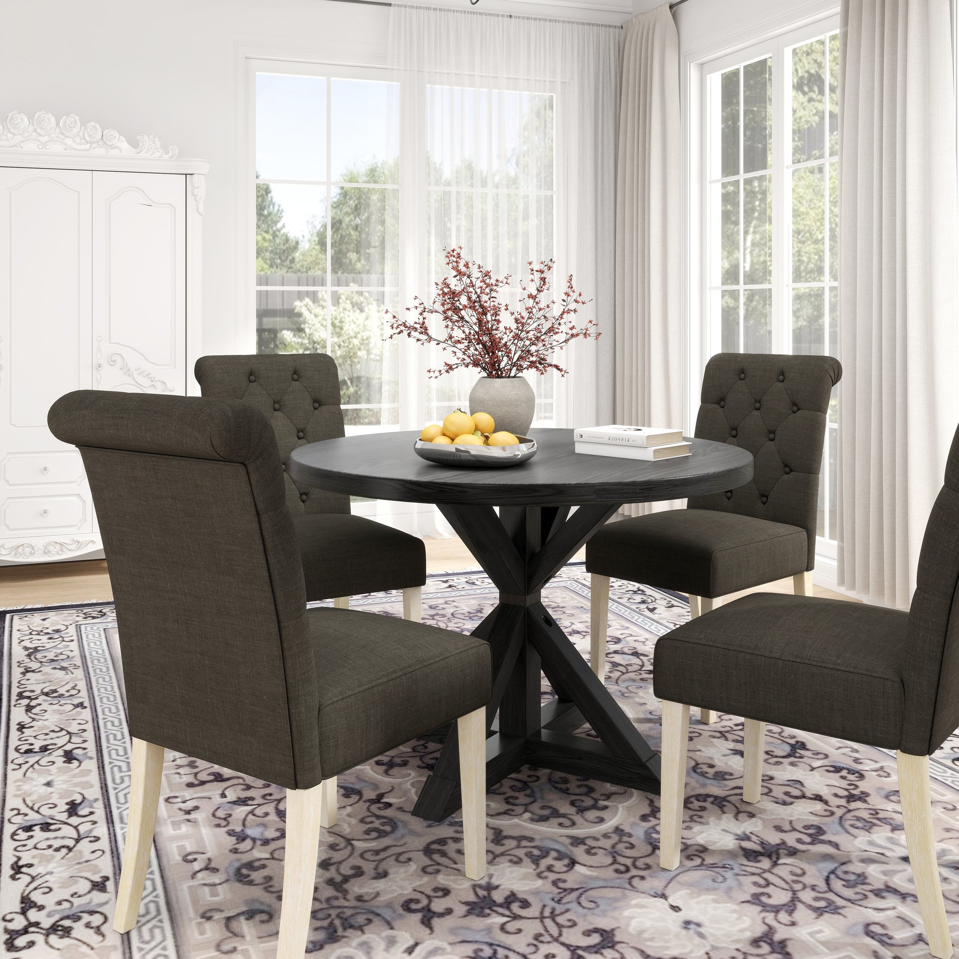 Dark grey tufted dining chairs around a round black dining table