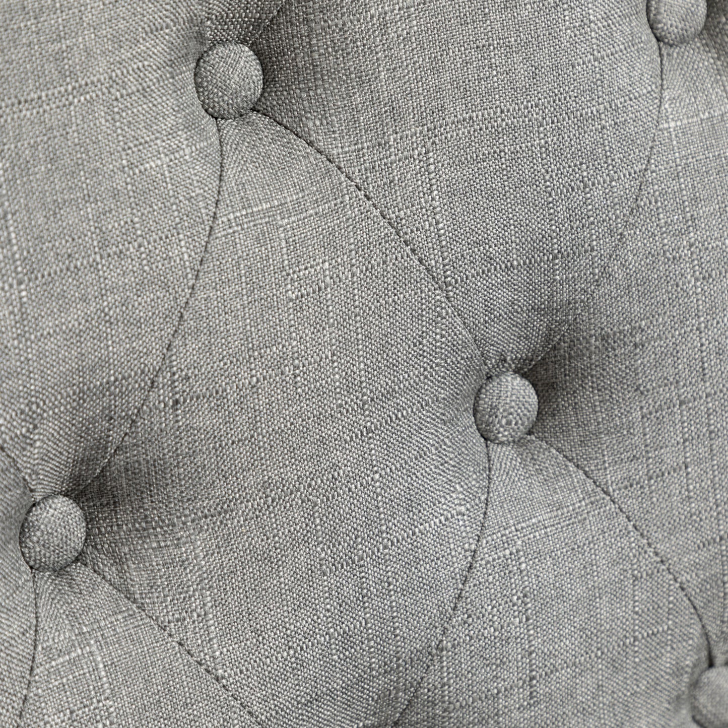 Closeup of grey textured fabric with diamond tufting detail