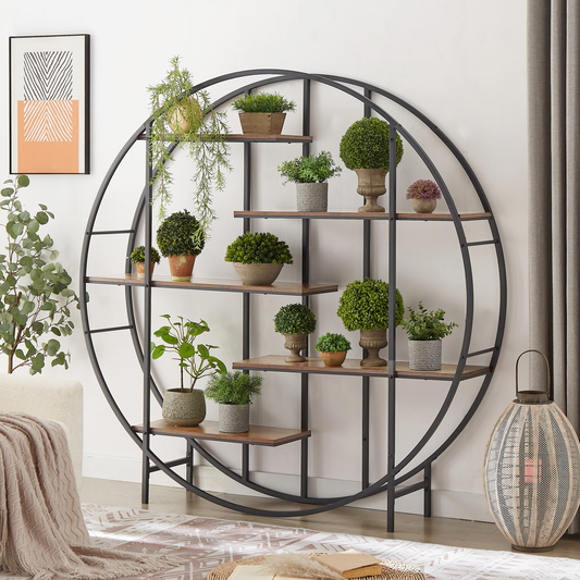 Round metal wall shelf displaying various faux plants in terracotta and stone pots