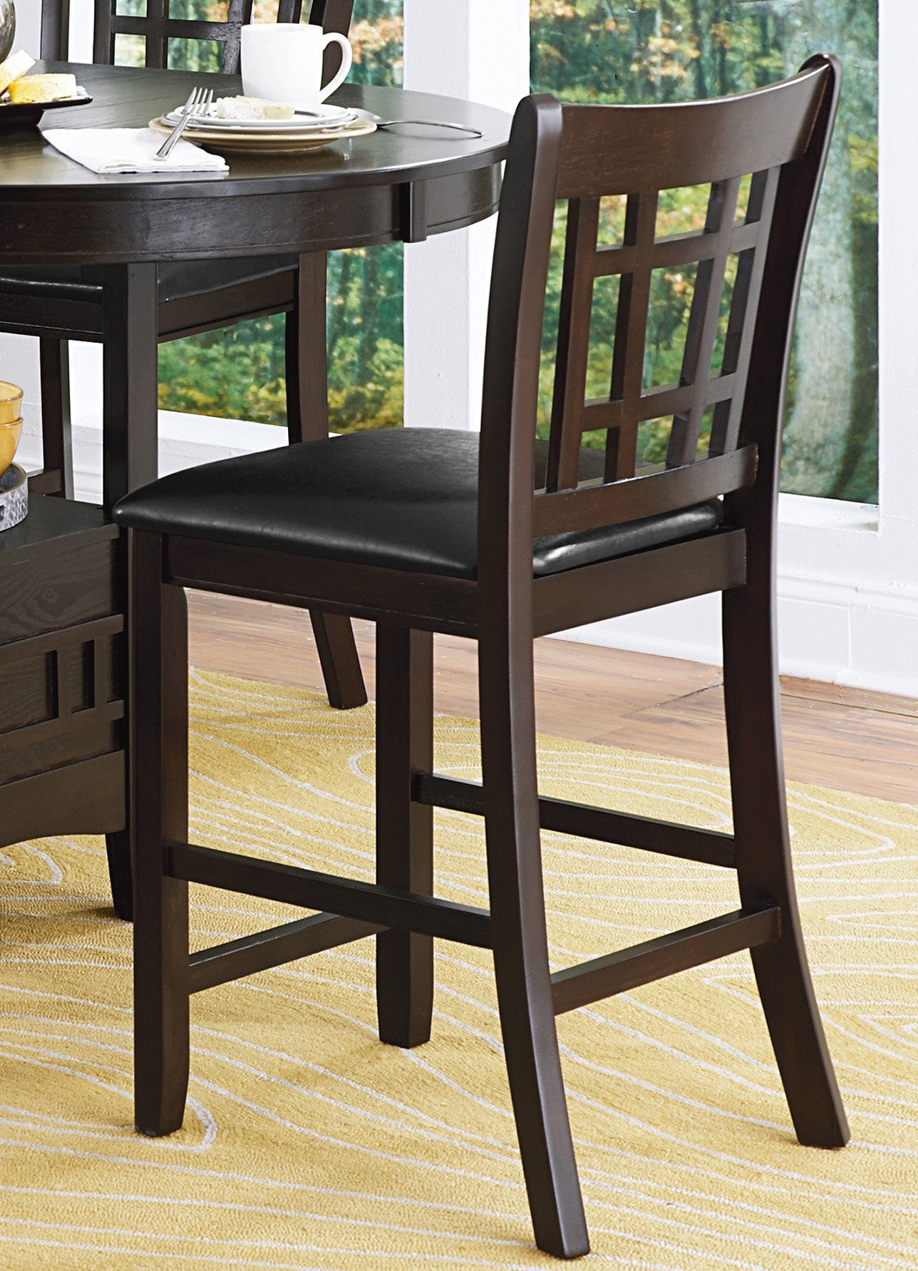 Dark brown wooden bar stool with black faux leather seat and geometric backrest