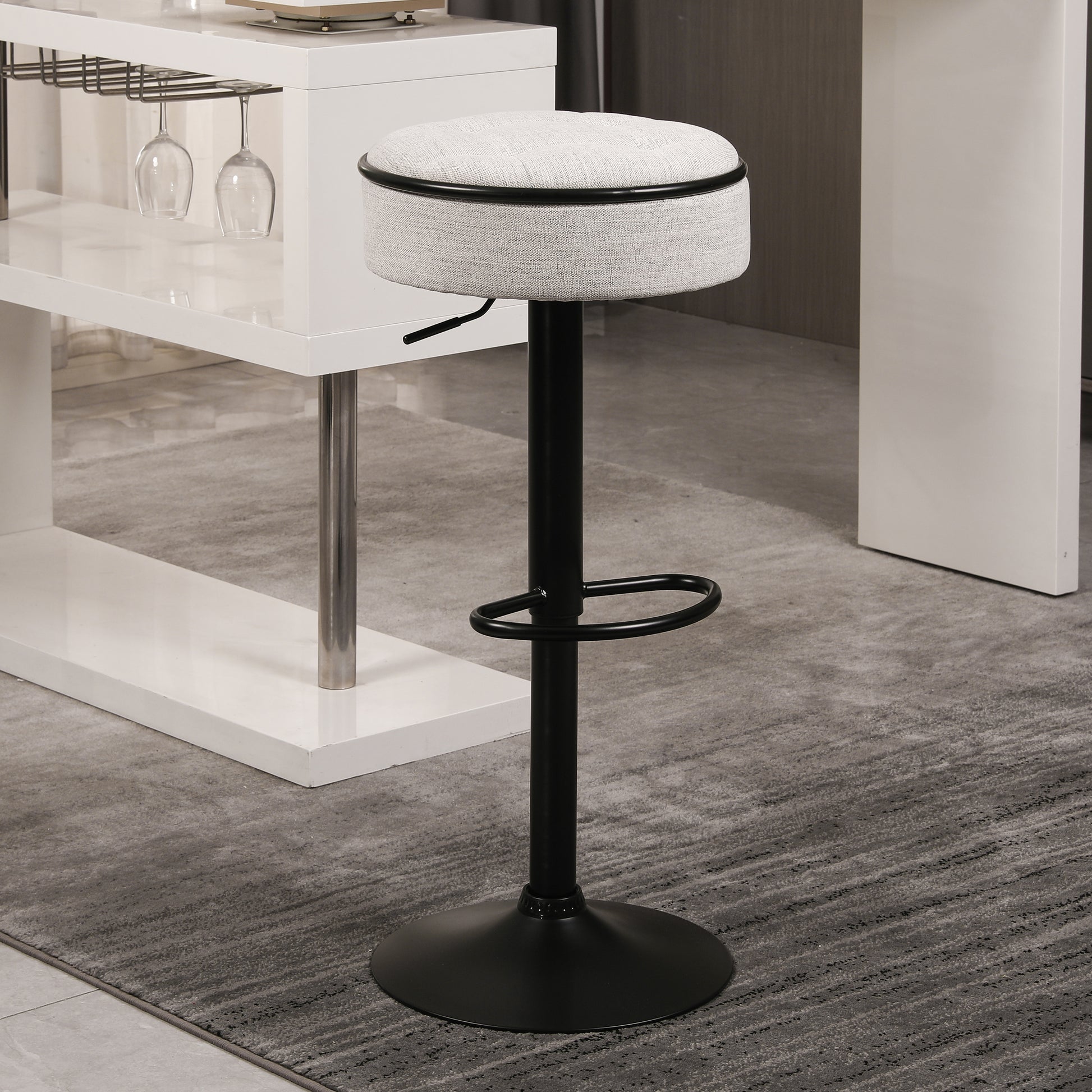 Gray upholstered bar stool with adjustable height and black metal base