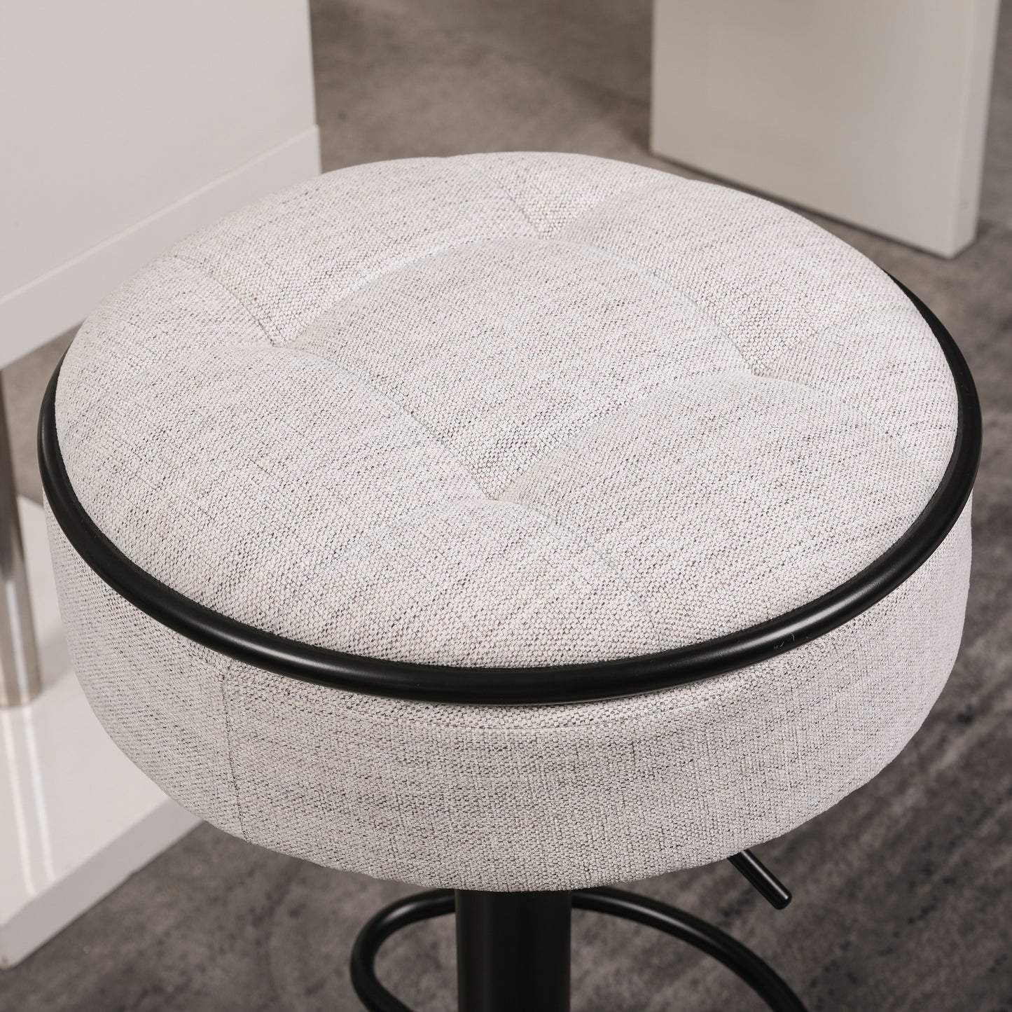 Tufted light gray fabric bar stool with black trim and adjustable height