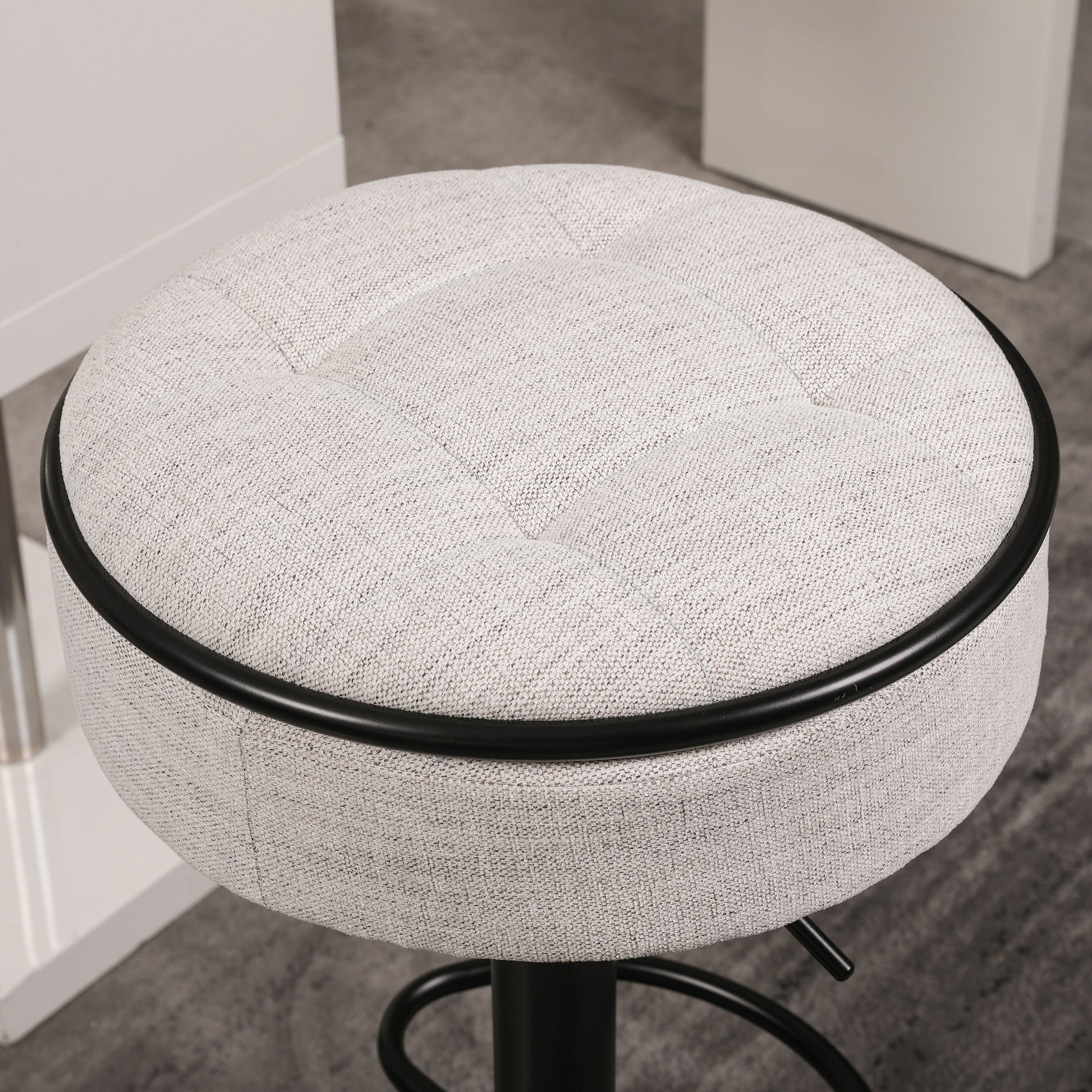 Tufted light gray fabric bar stool with black trim and adjustable height