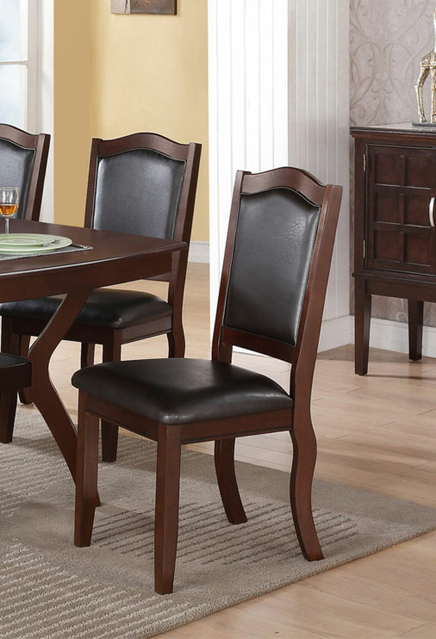 Dark brown wooden dining chair with black faux leather seat