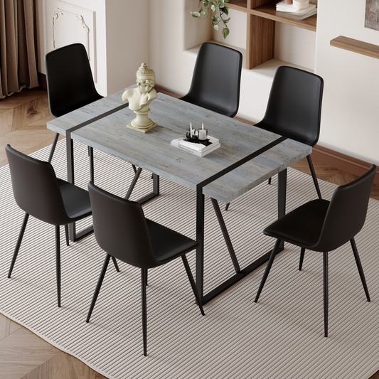 Gray wood dining table set with six black chairs and decorative bust