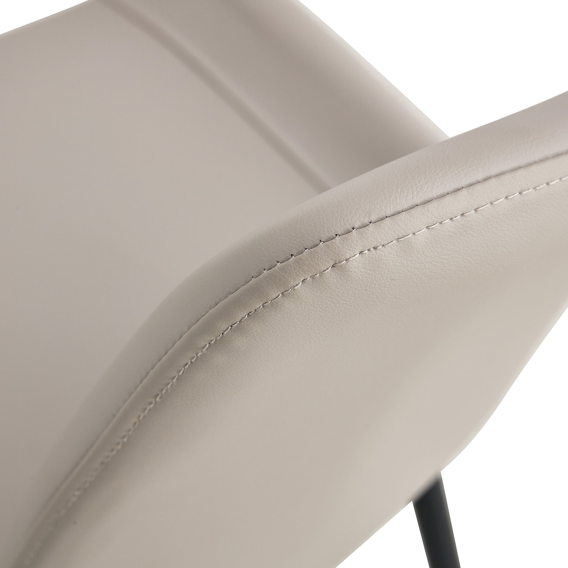 Closeup of a light grey vegan leather chair armrest with detailed stitching