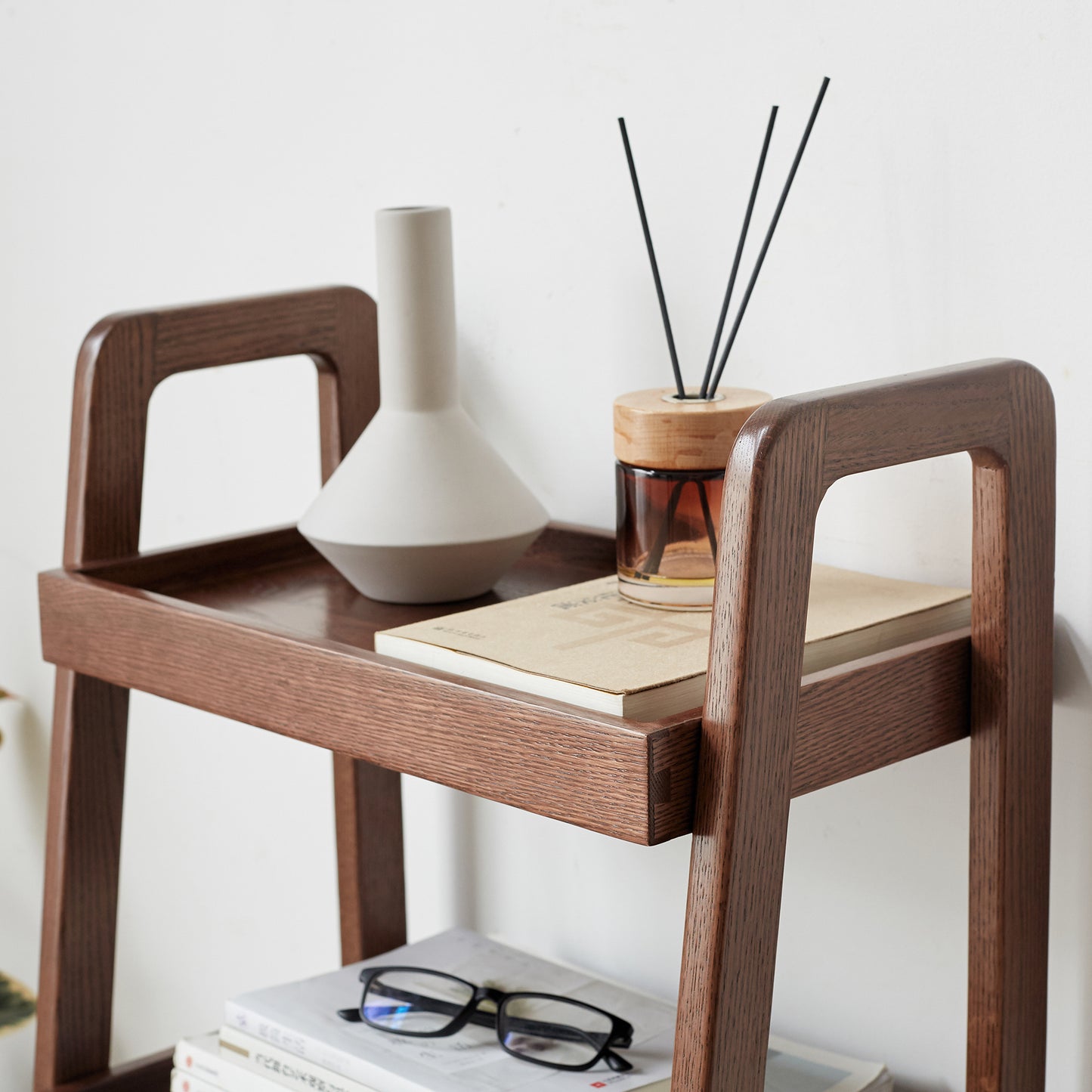 Modern minimalist wood shelf with ceramic vase and diffuser