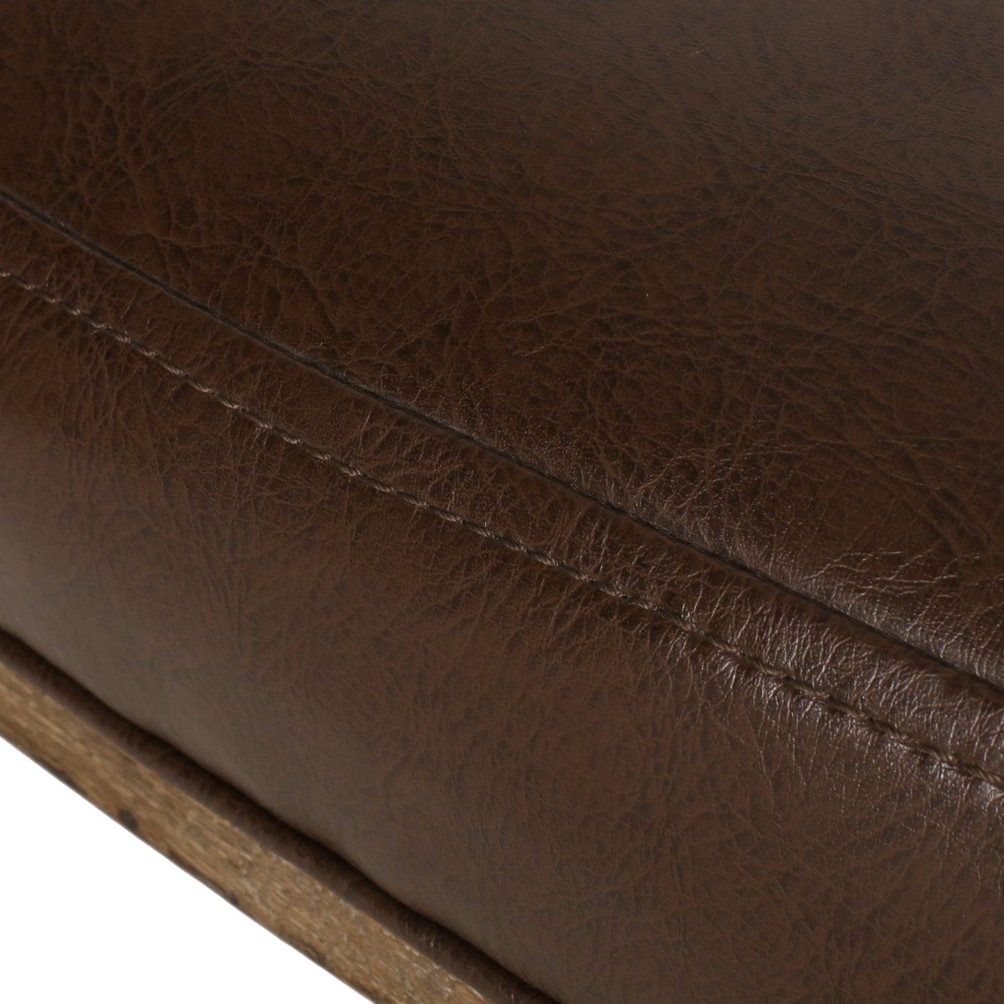 Closeup of brown faux leather upholstery with visible stitching