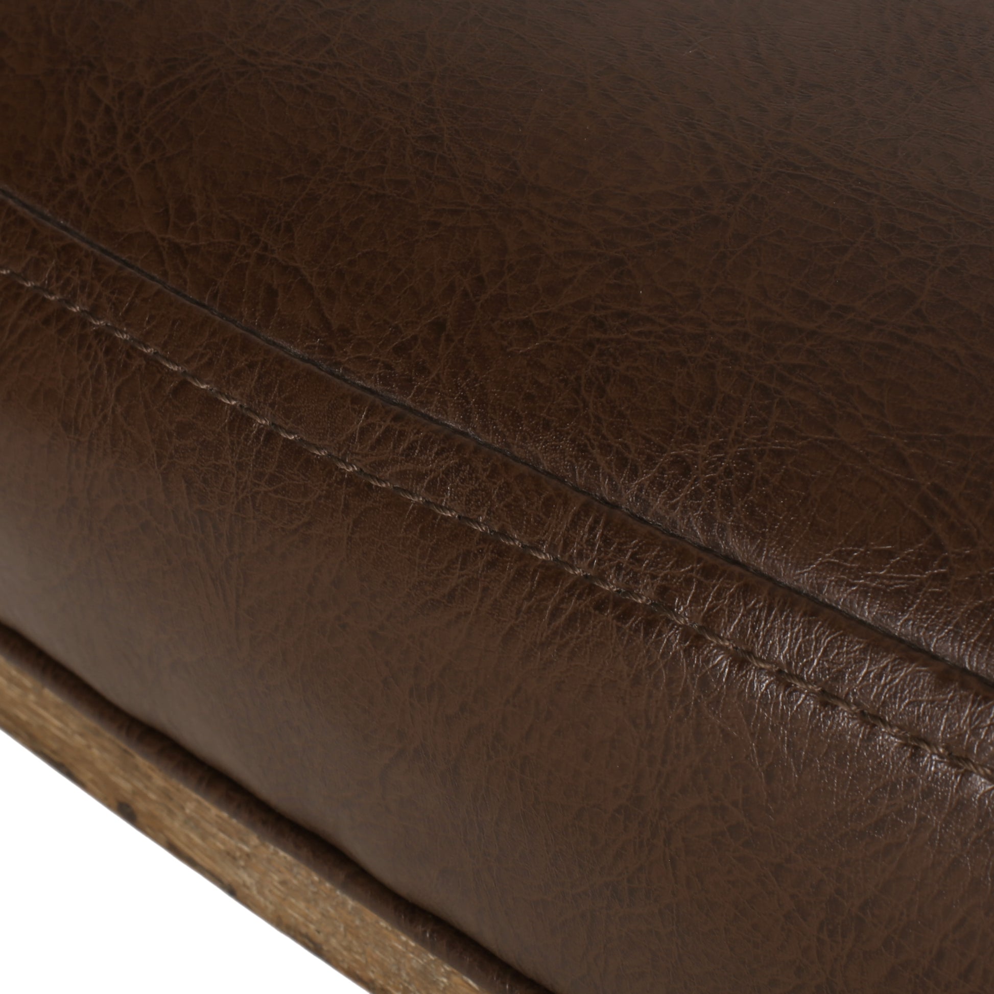 Closeup of brown faux leather upholstery with visible stitching