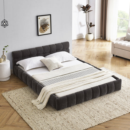 Dark gray tufted platform bed frame with white linens and throws