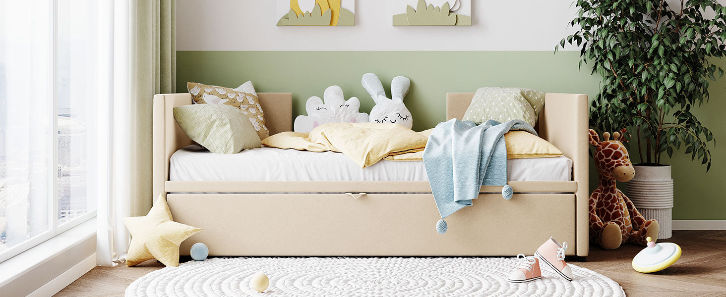 Cream upholstered daybed with pastel bedding and stuffed animals