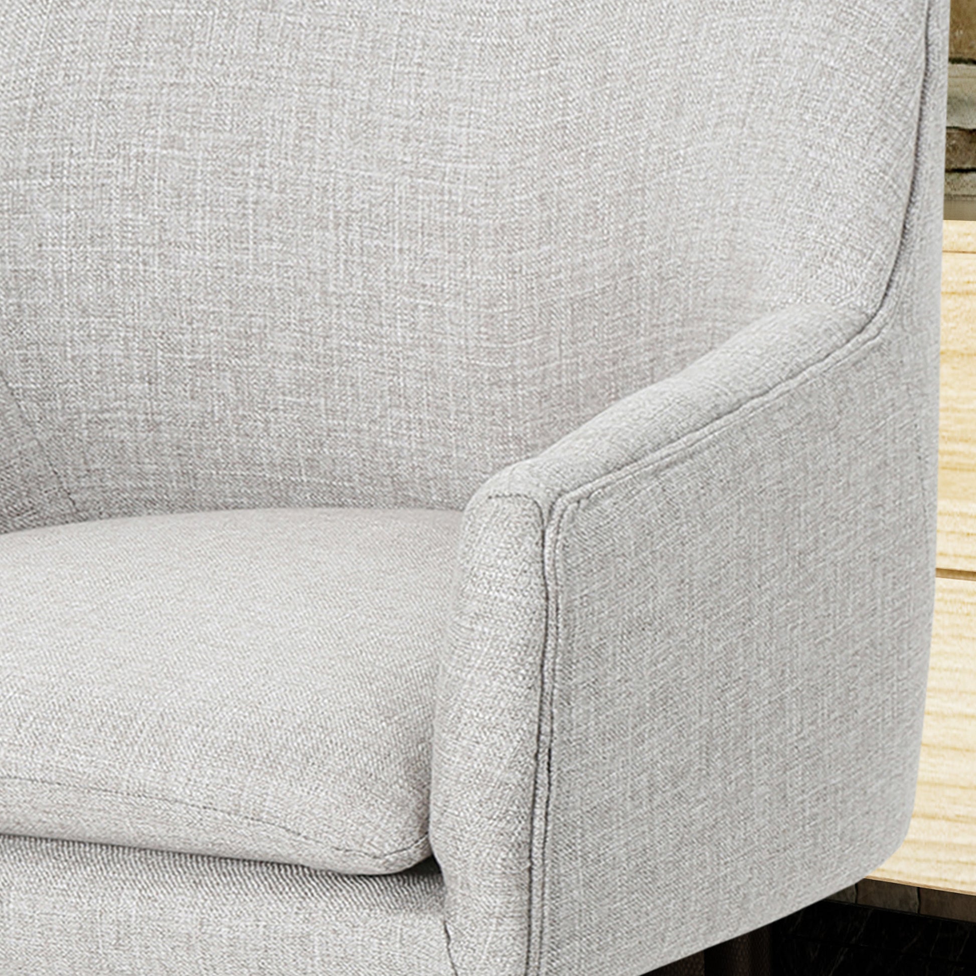 Light gray textured fabric armchair armrest and seat detail