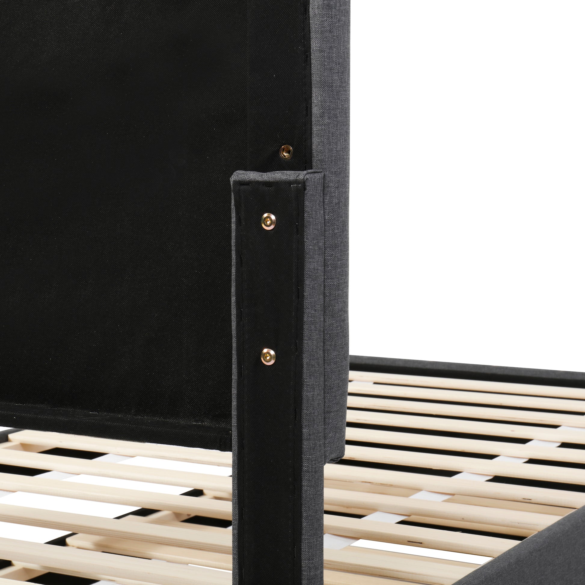 Closeup of a dark gray upholstered bed frame with visible wooden slats