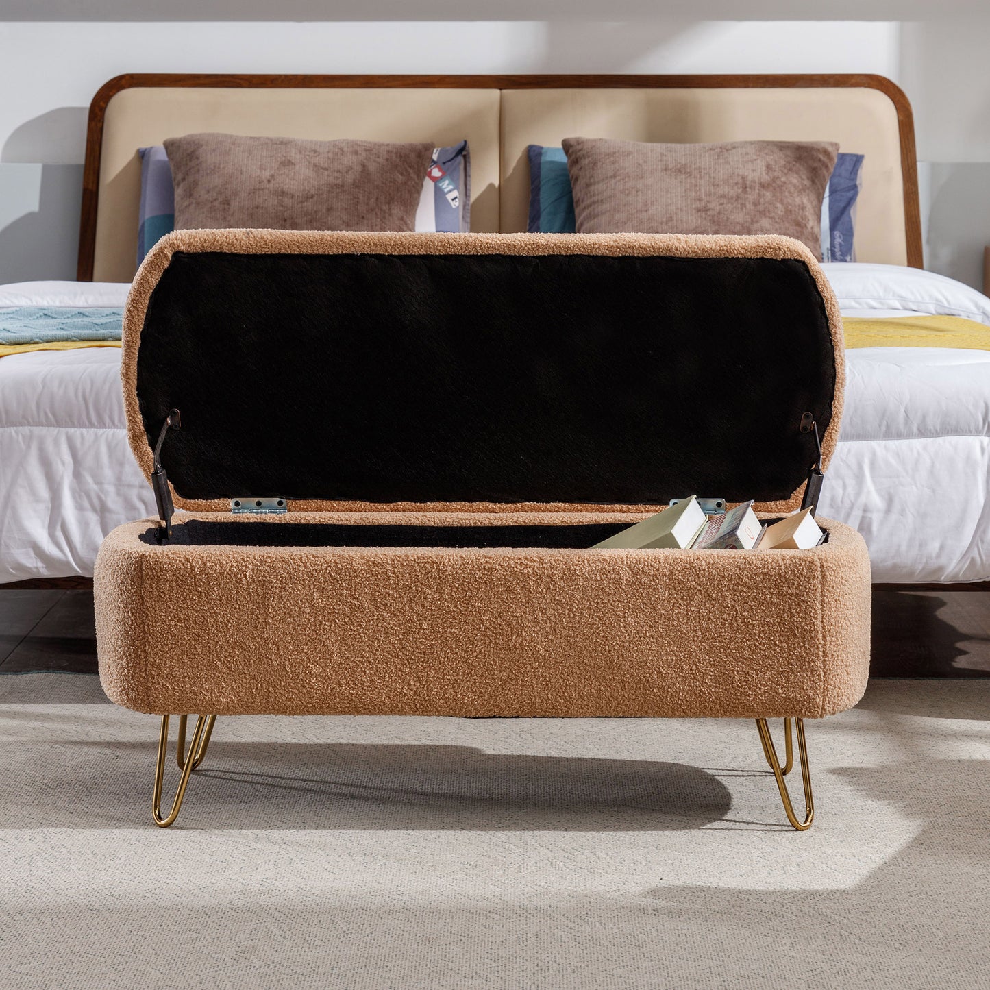 Open tan boucle storage ottoman with gold hairpin legs perfect for bedroom entryways