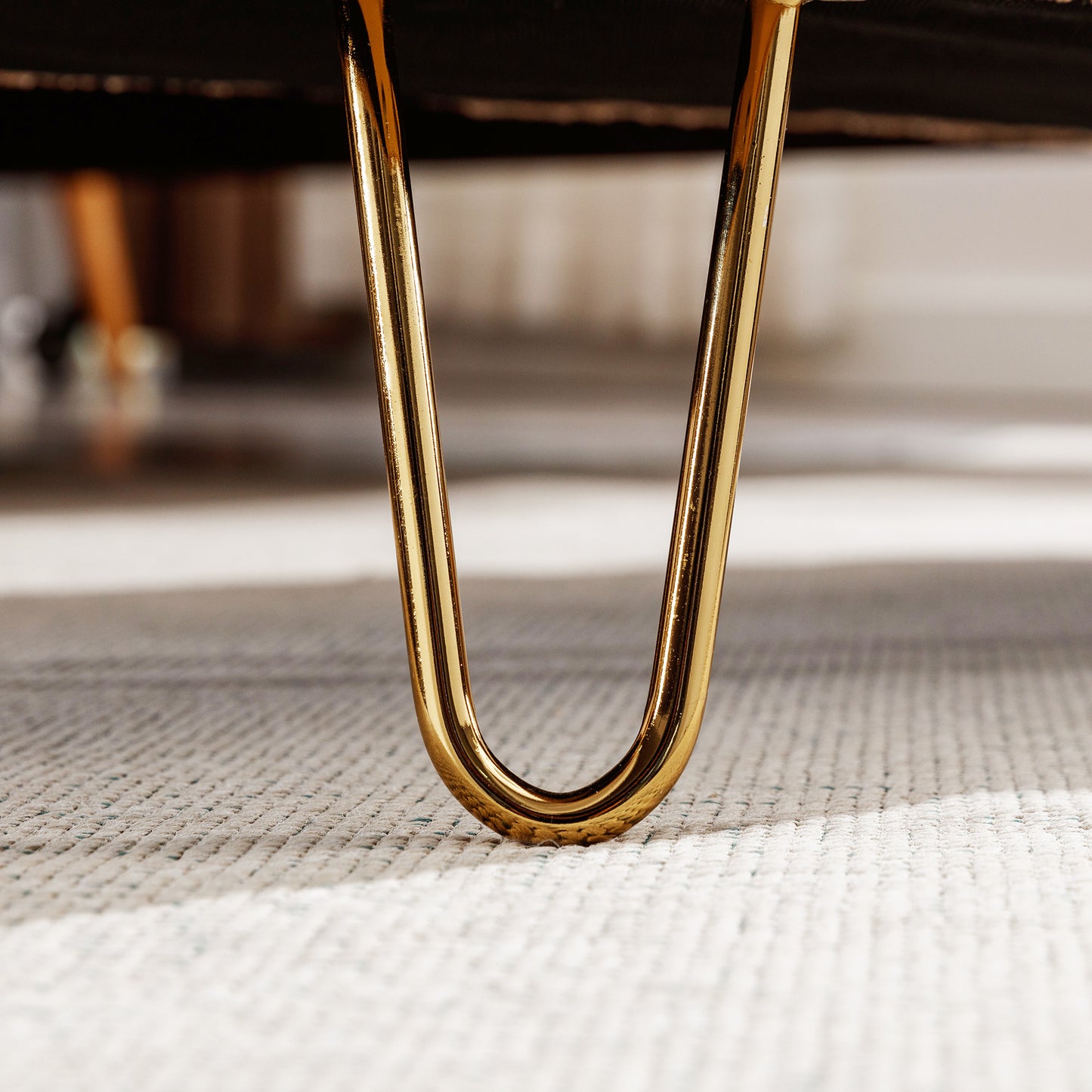 Polished gold hairpin leg detail for modern furniture