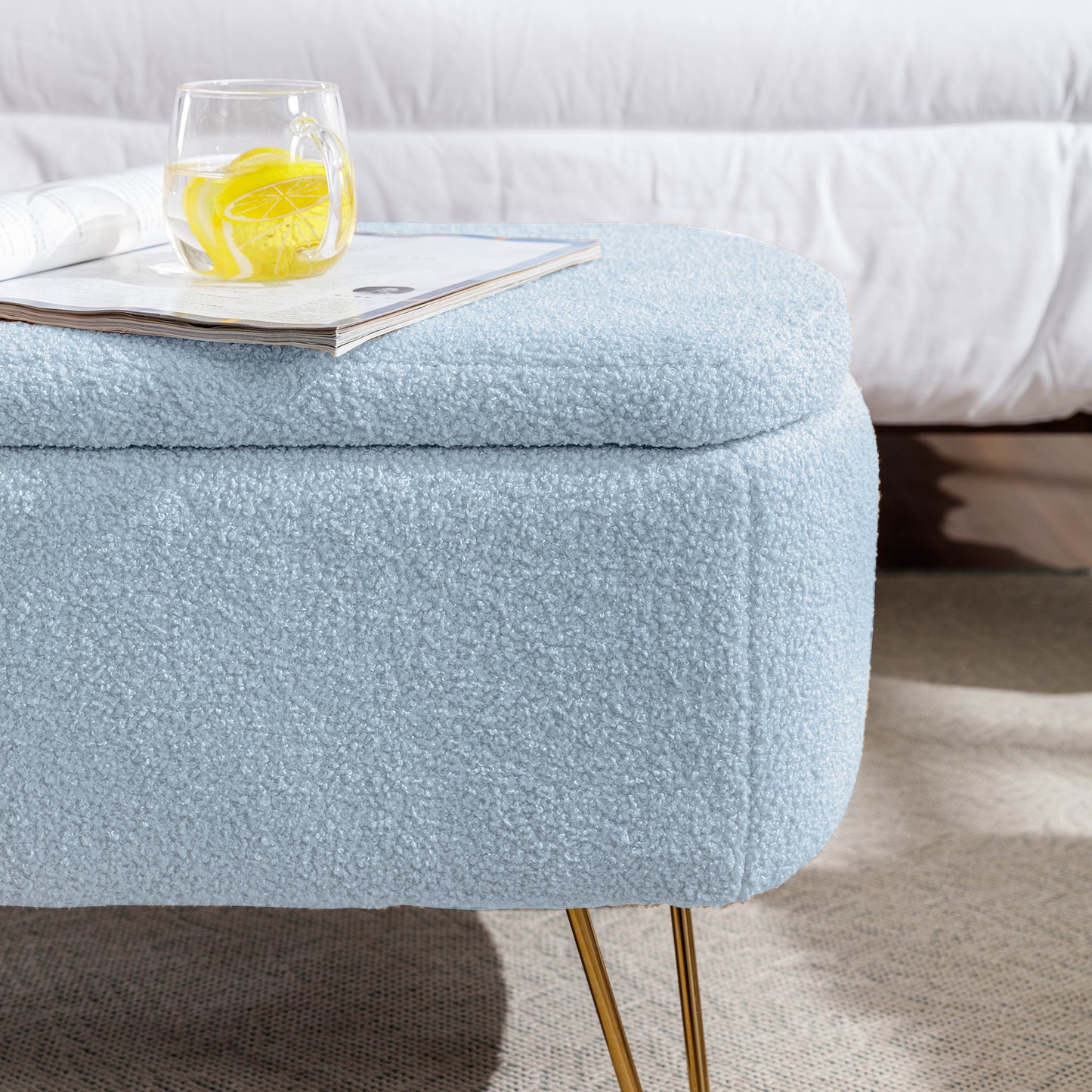 Light blue boucle storage ottoman with gold legs