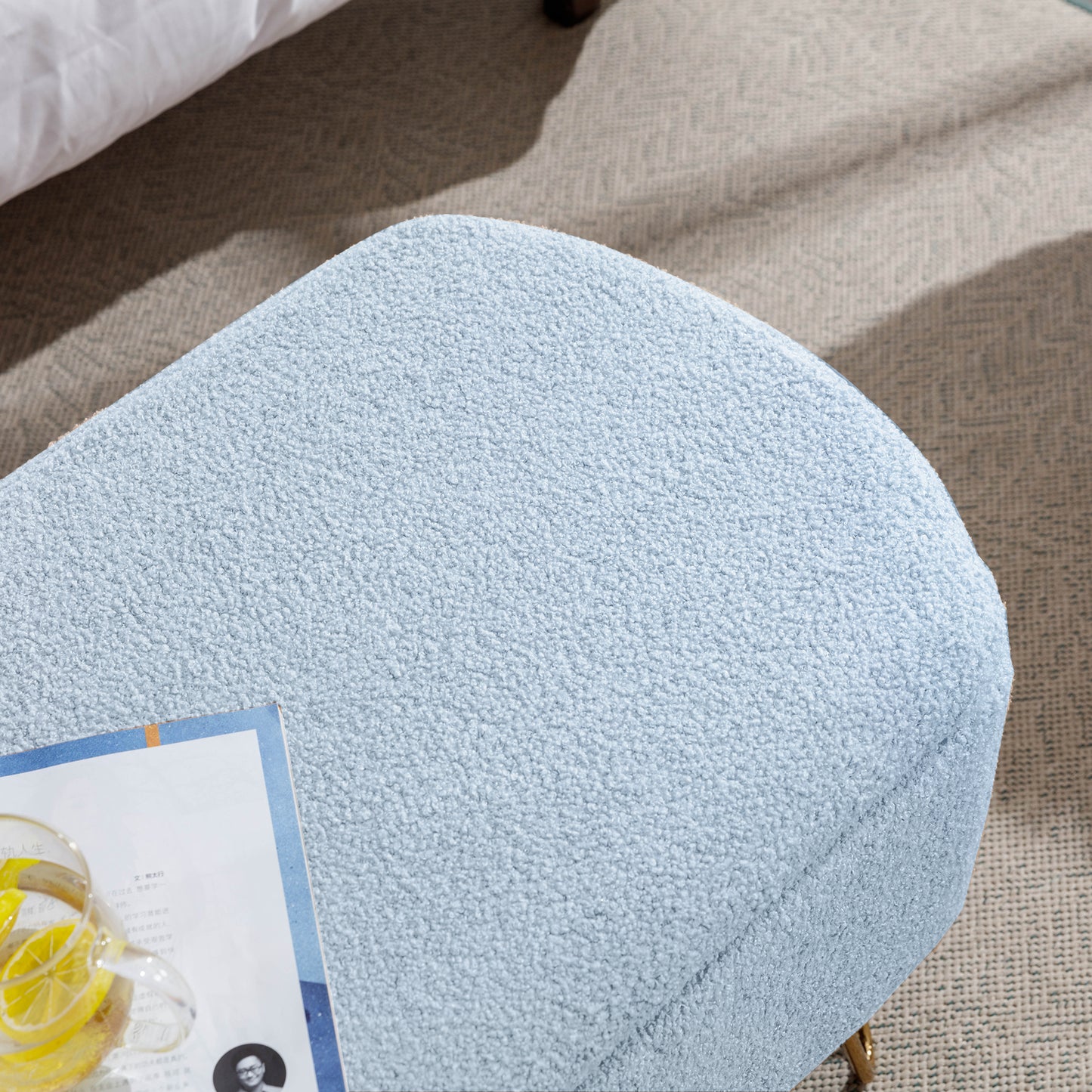 Light blue boucle fabric ottoman with curved edges on a neutral rug