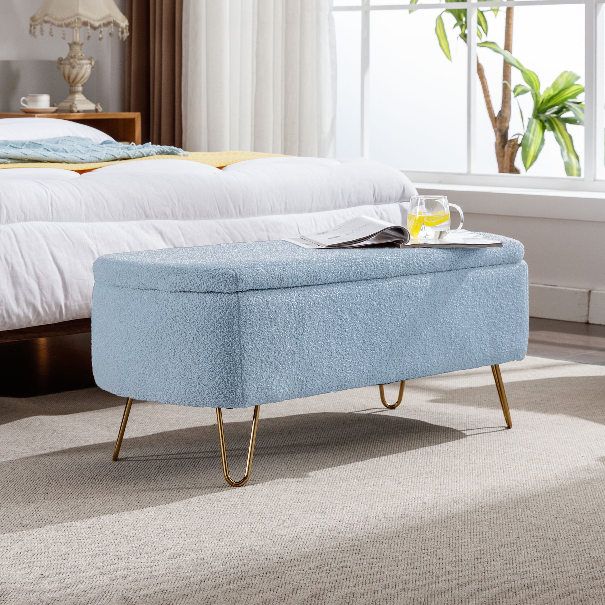 Light blue boucle storage ottoman with gold hairpin legs