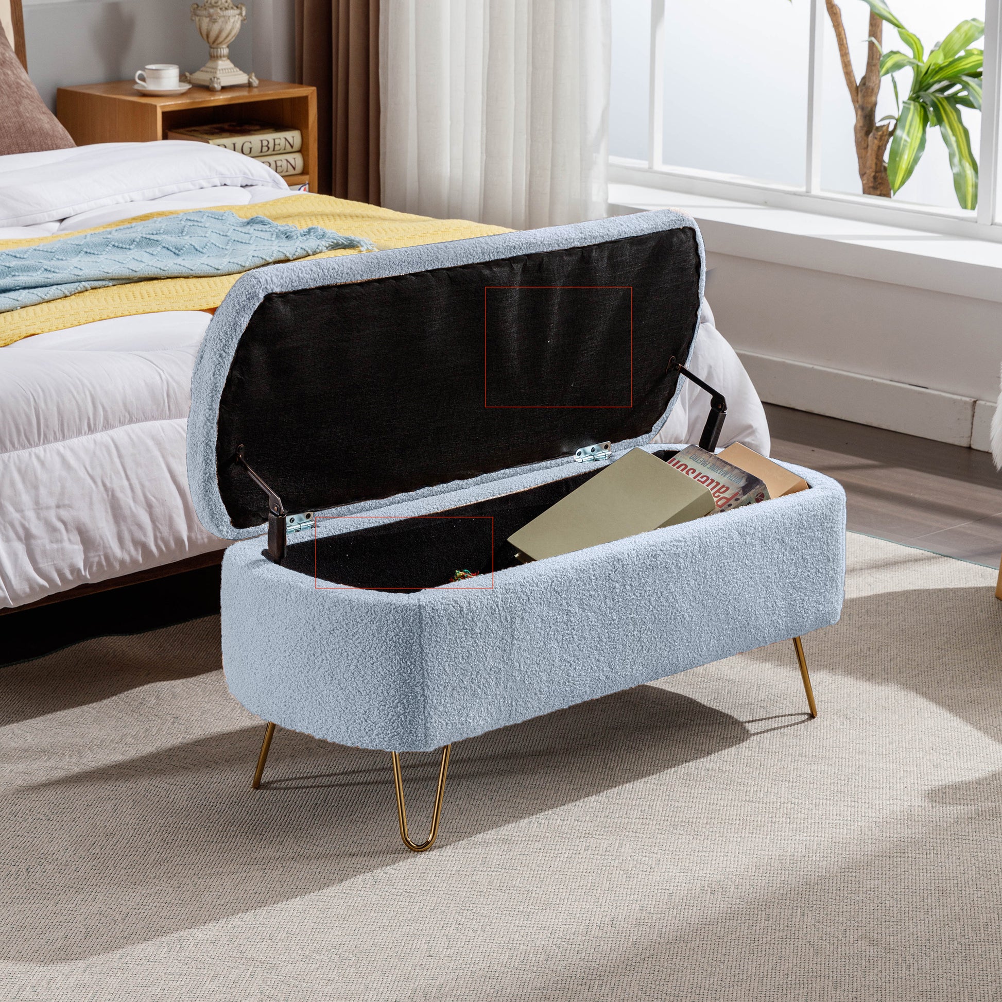 Light blue boucle storage bench with gold legs open to reveal books