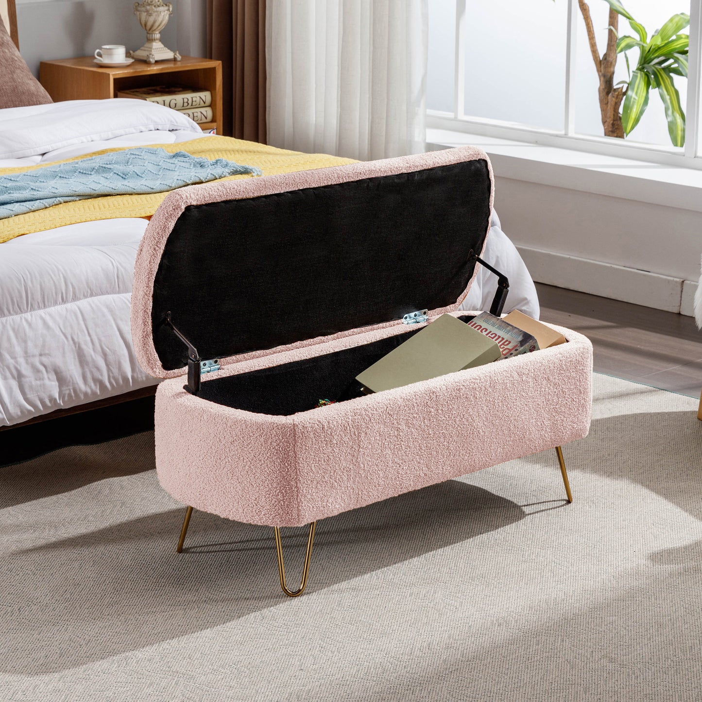 Pink boucle storage ottoman with gold hairpin legs open to reveal storage