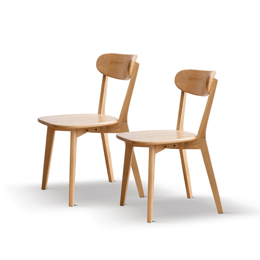 Two natural oak dining chairs with curved backrests