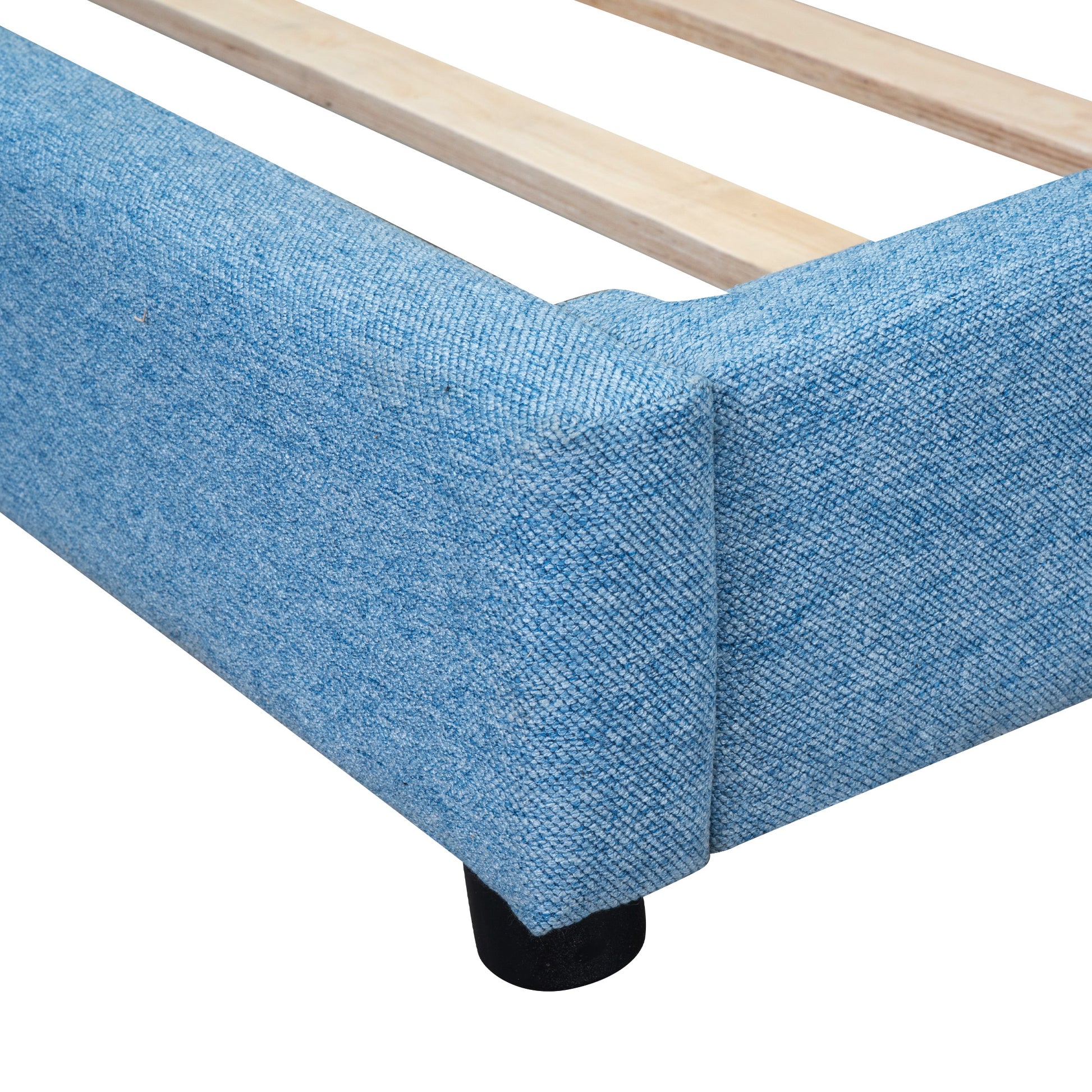 Closeup of a blue upholstered bed frame corner with wooden slats visible