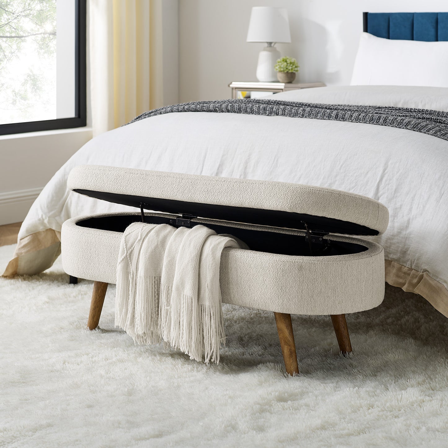 Cream textured storage bench with open lid and white throw