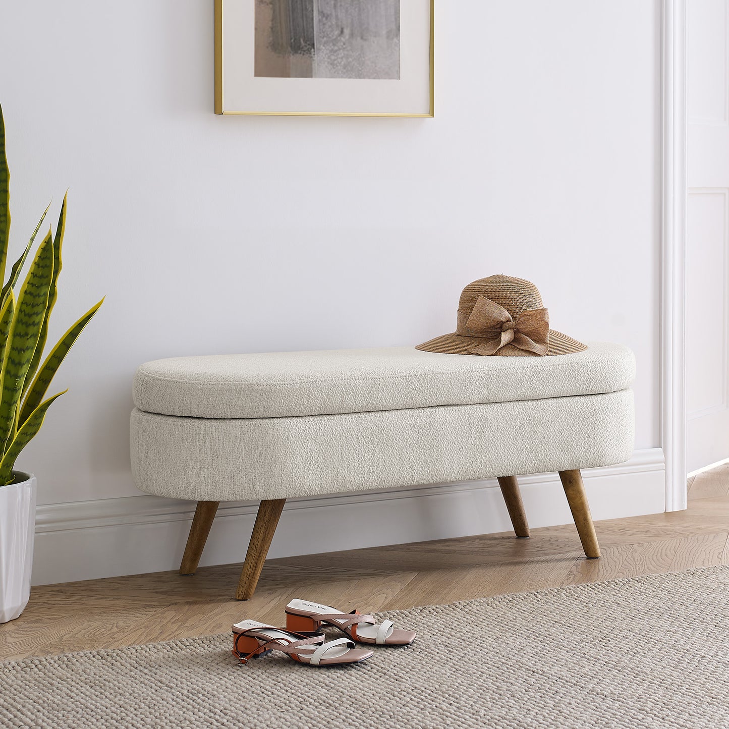 Cream boucle storage ottoman with wooden legs and straw hat