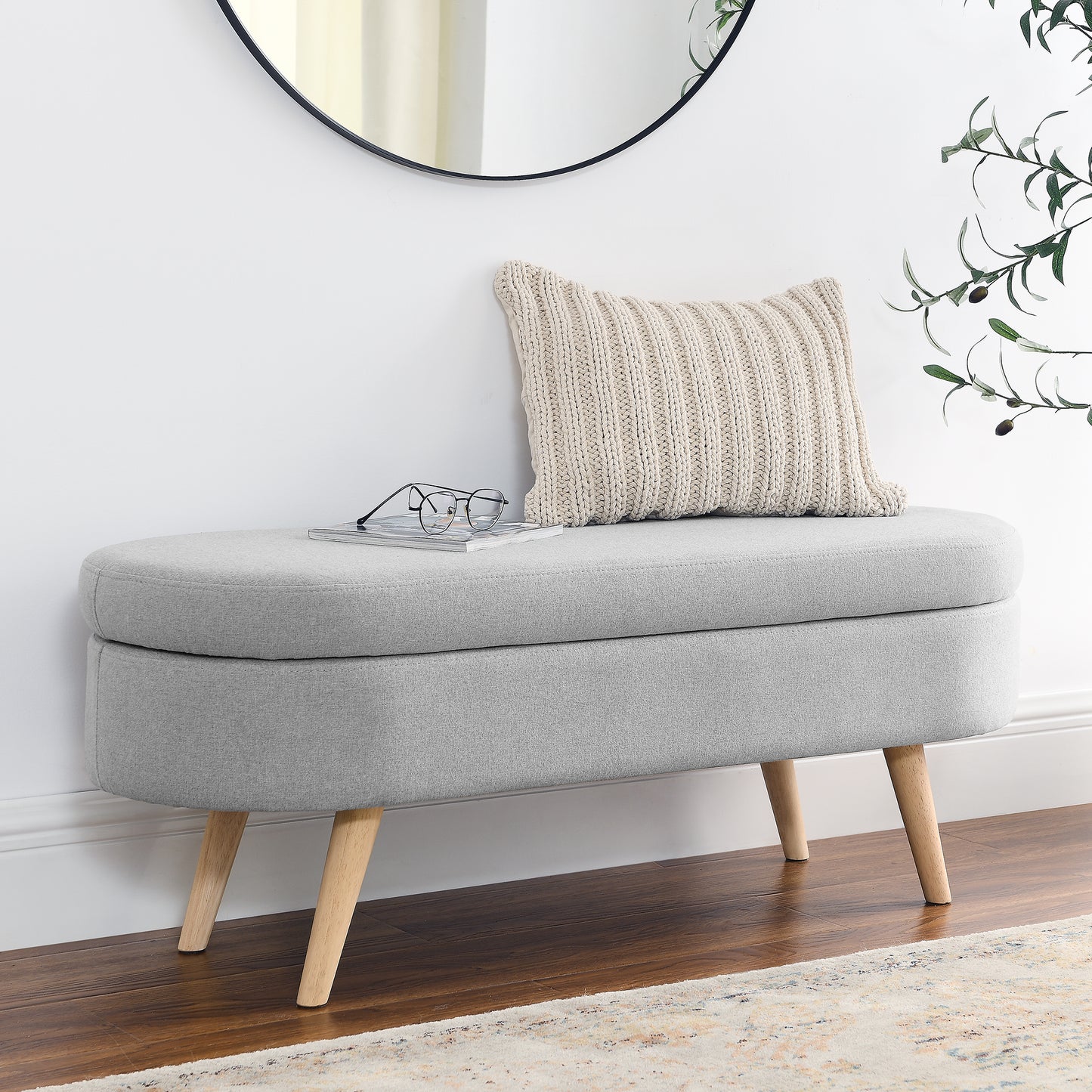 Grey fabric storage ottoman with carved wooden legs
