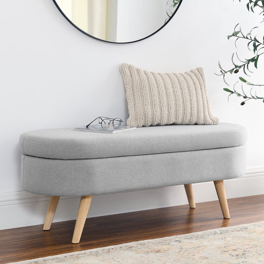 Grey fabric storage ottoman with carved wooden legs