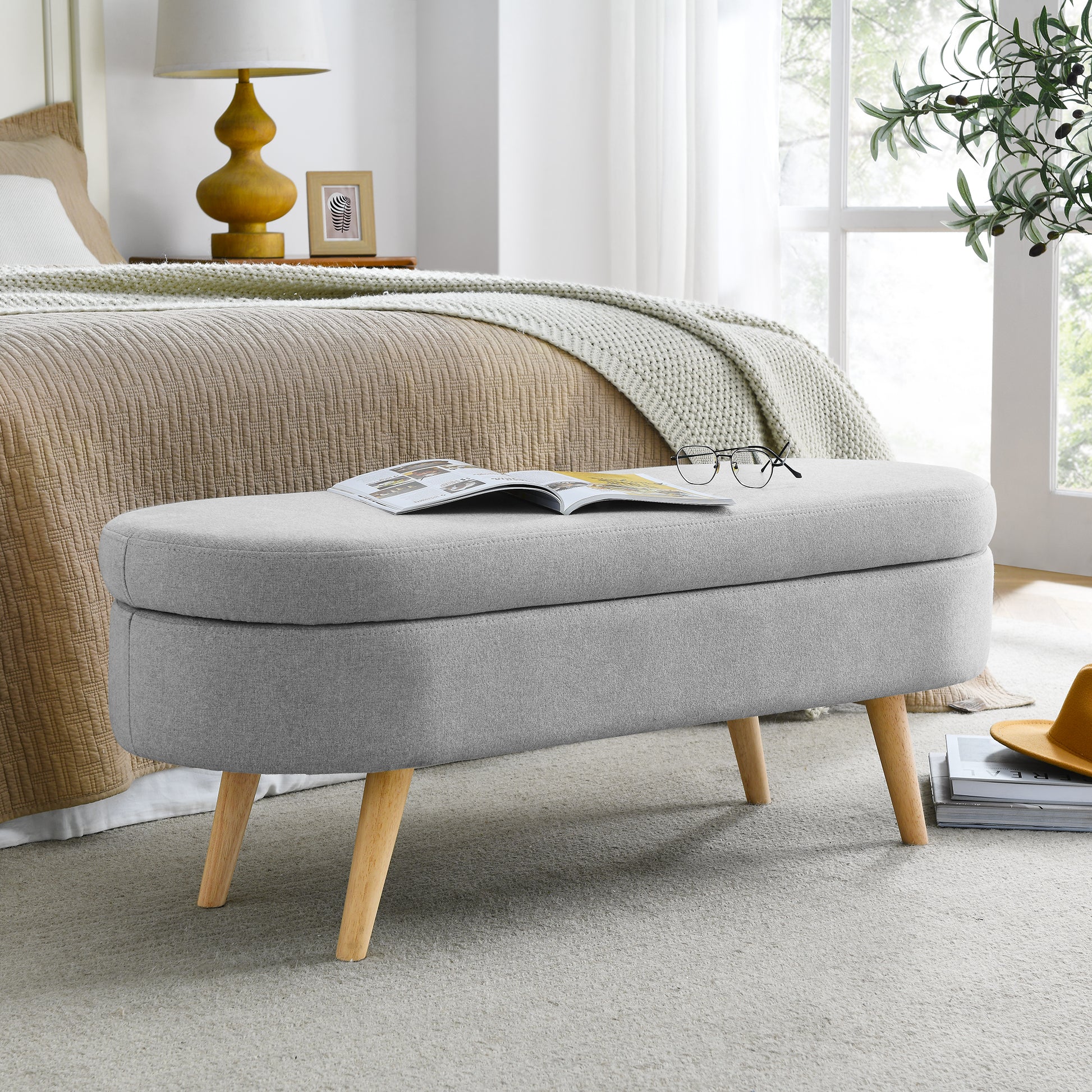 Grey upholstered storage bench with wooden legs ideal for bedroom organization