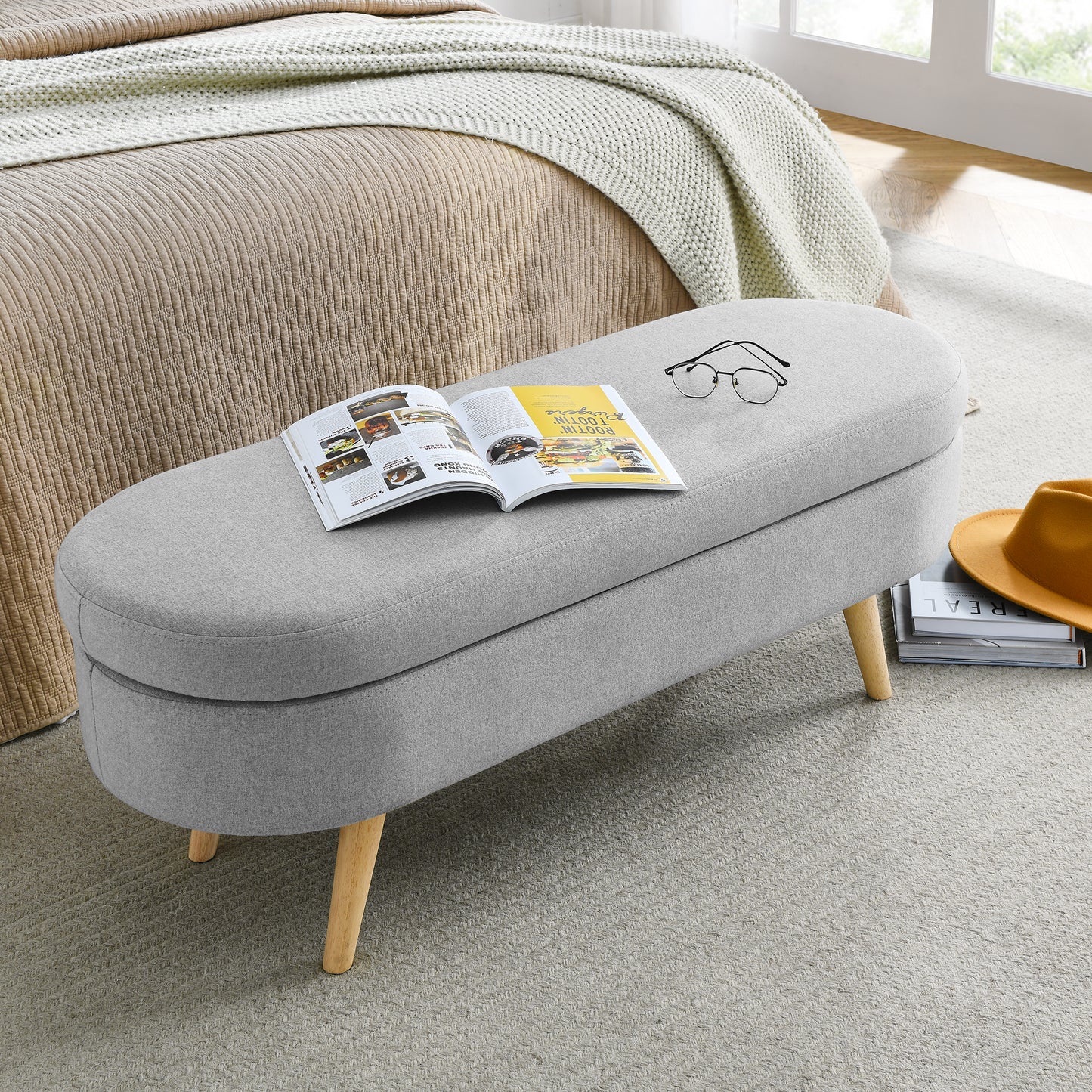 Grey linen storage bench with wooden legs and open magazine