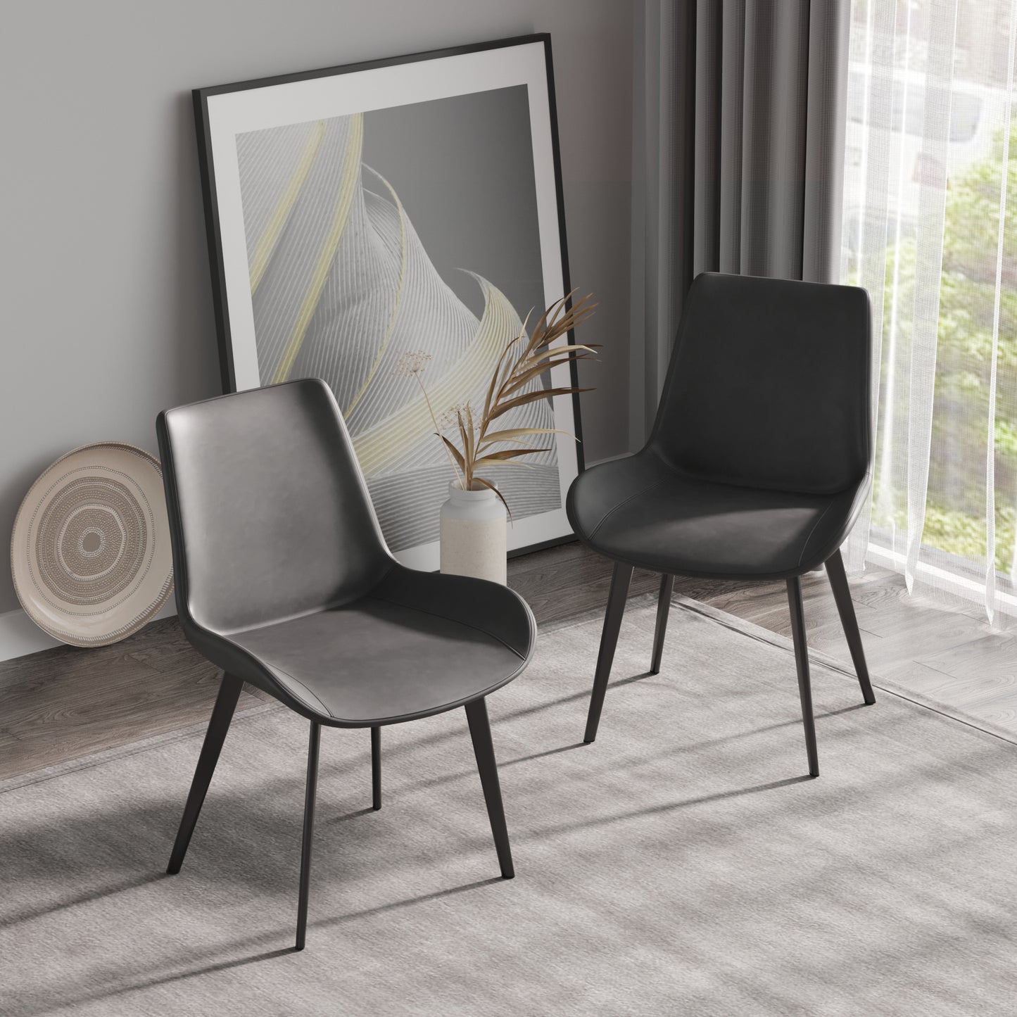 Two charcoal vegan leather dining chairs with dark metal legs