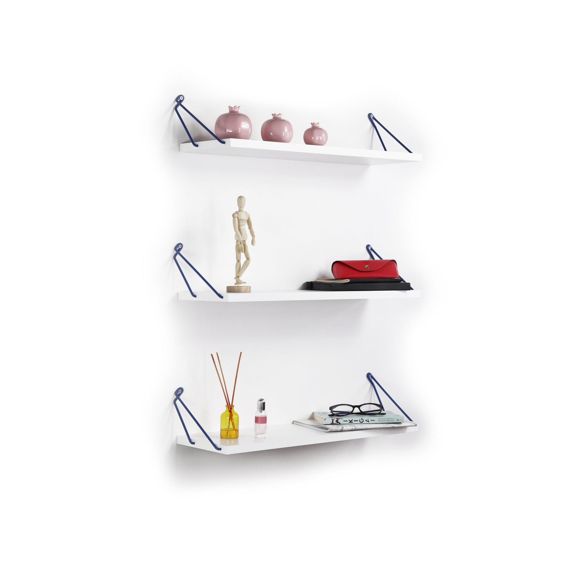 Three pink ceramic pomegranate decor pieces displayed on a modern white shelf