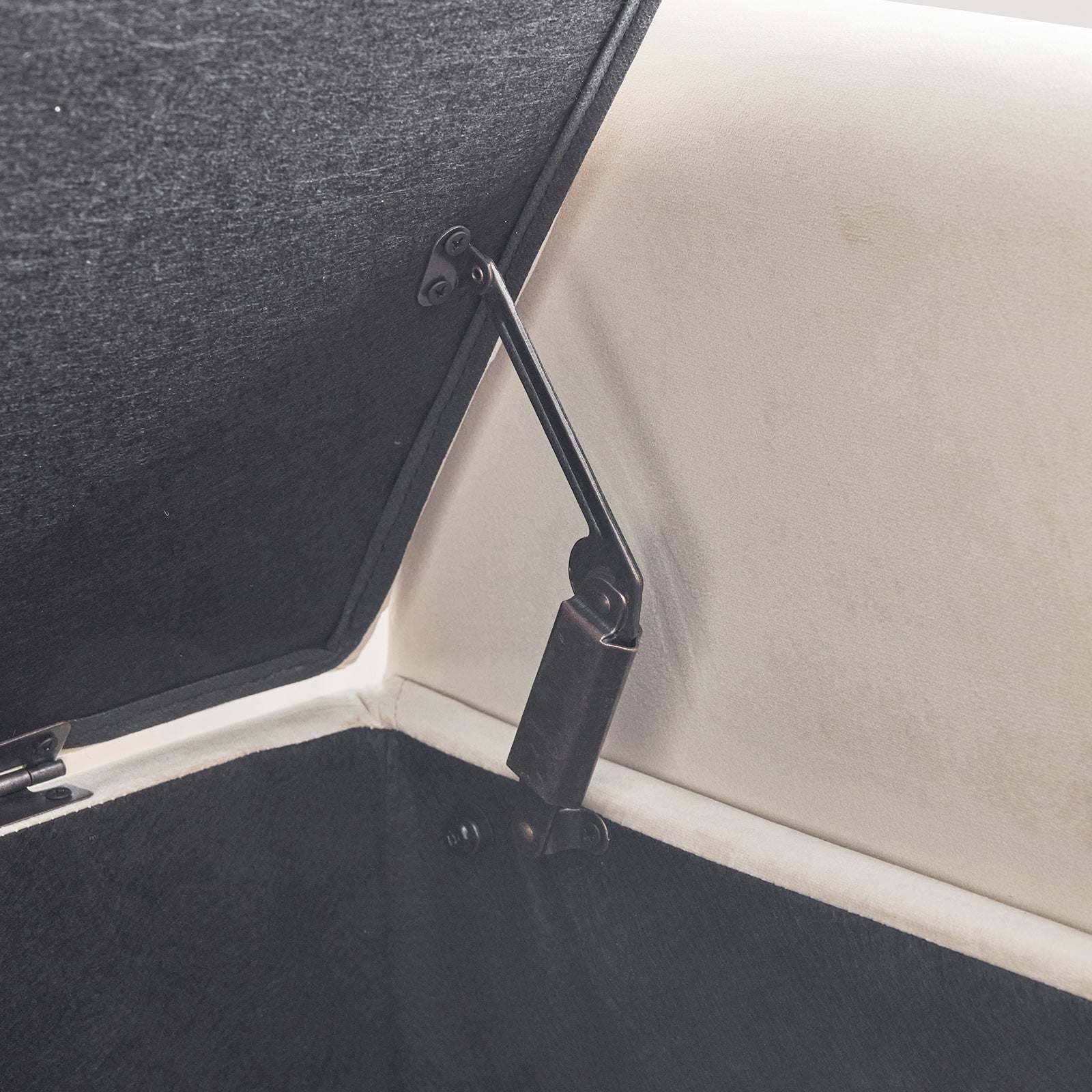 Black velvet upholstered ottoman interior with hydraulic lift mechanism visible