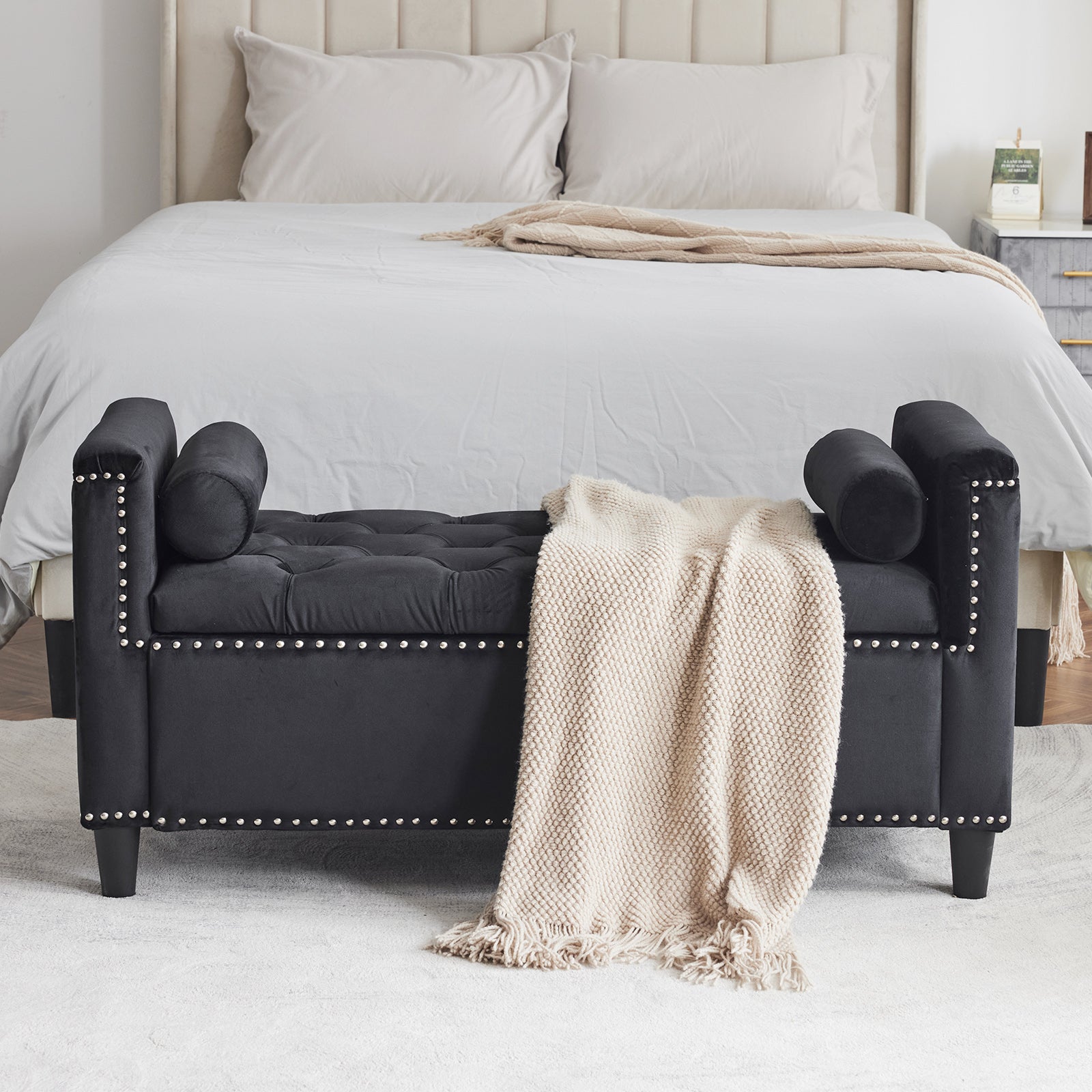 Black velvet storage bench with tufted seat and silver nailhead trim