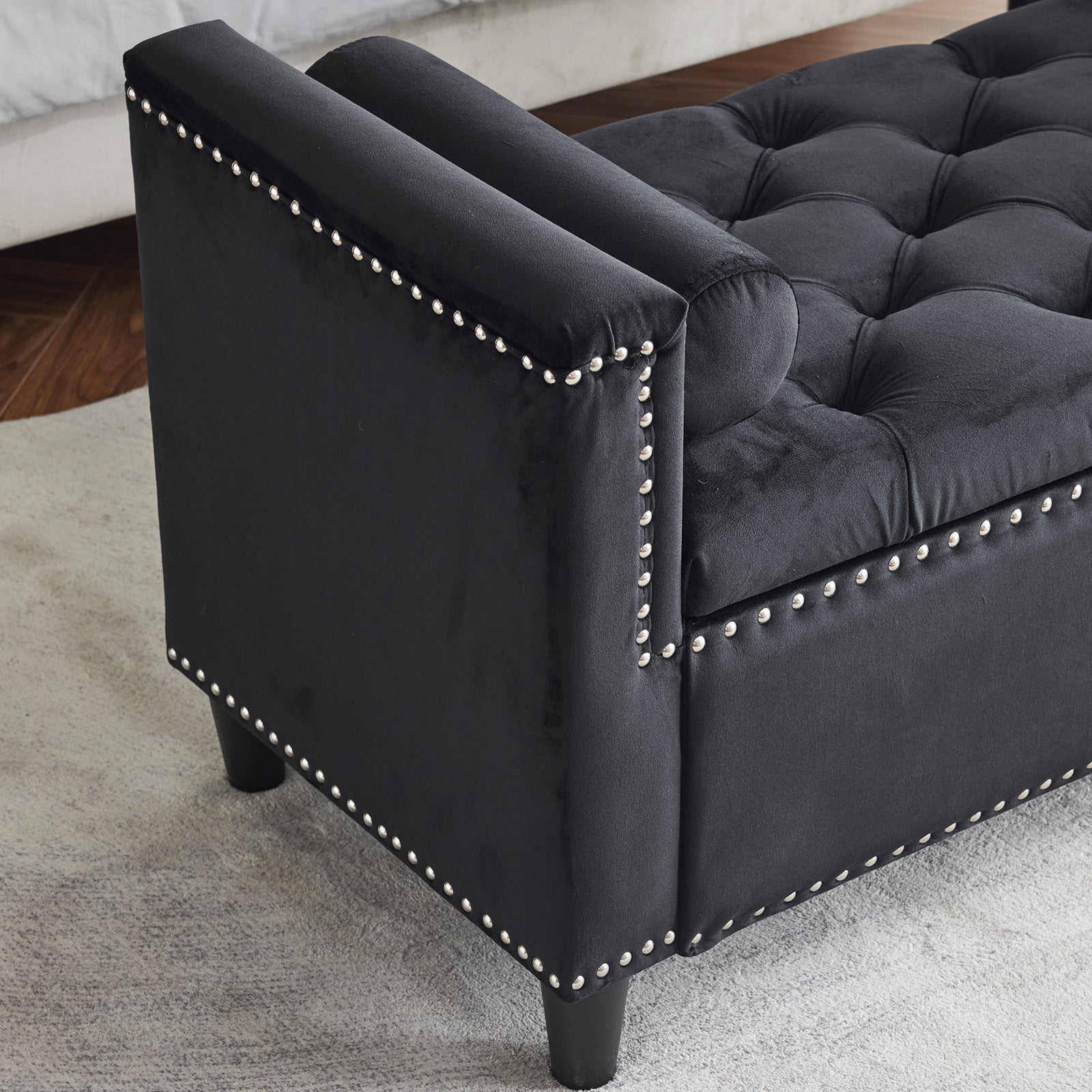 Black velvet storage bench with tufted seat and silver nailhead trim