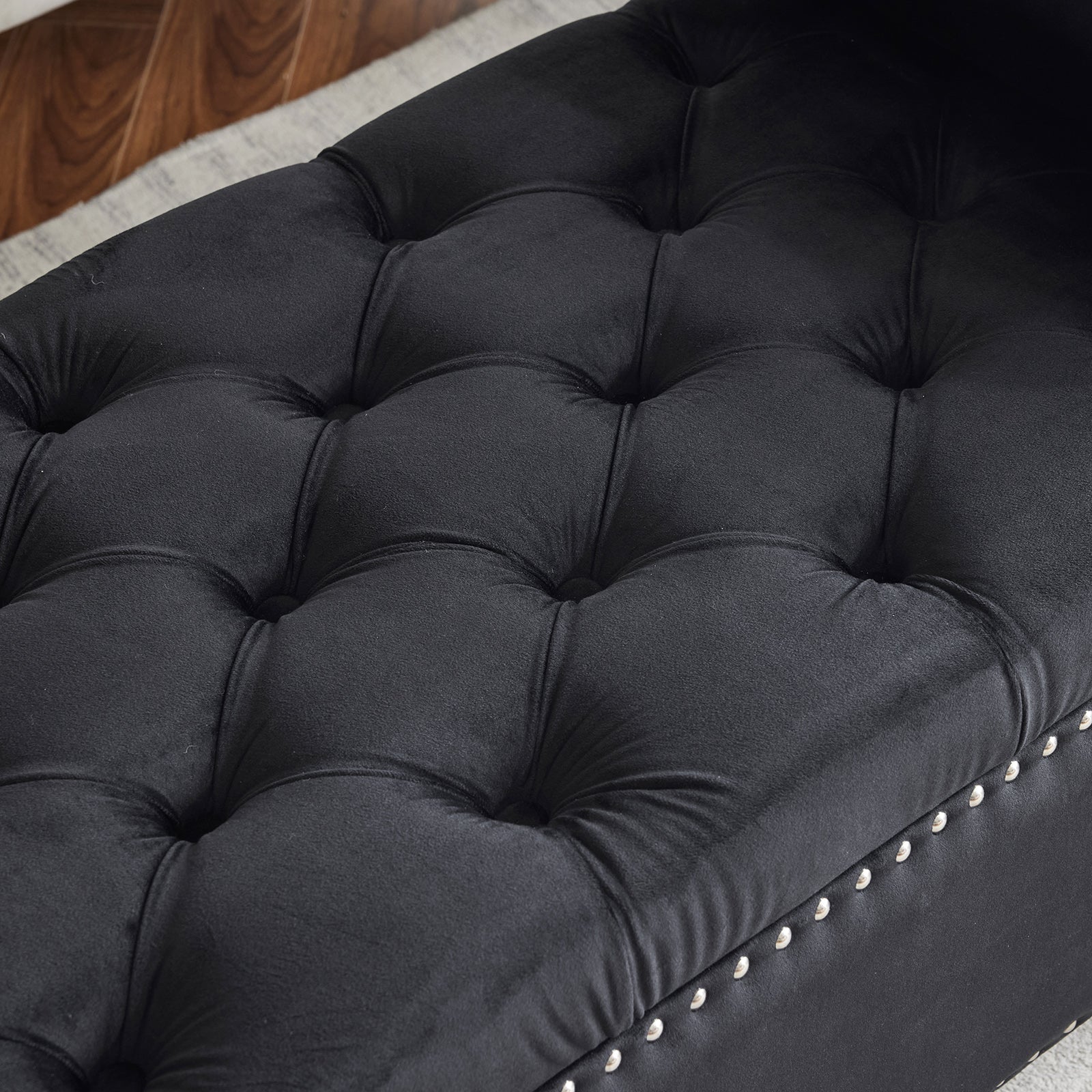 Black velvet storage ottoman with tufted top and silver nailhead trim